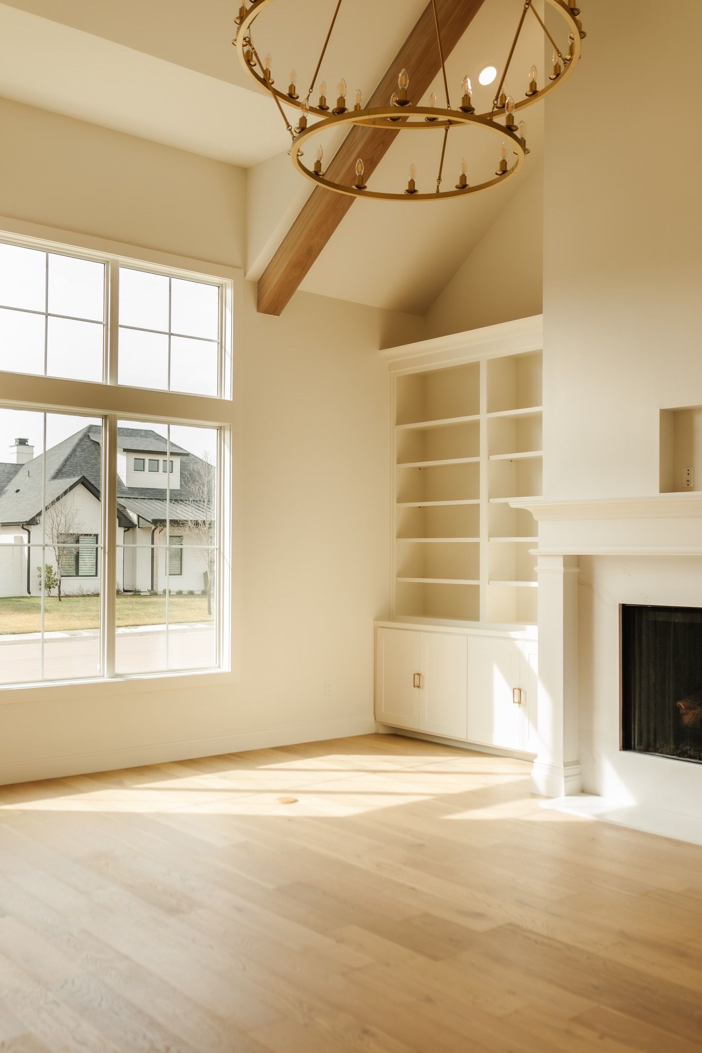 An empty living room with a fireplace and lots of windows.