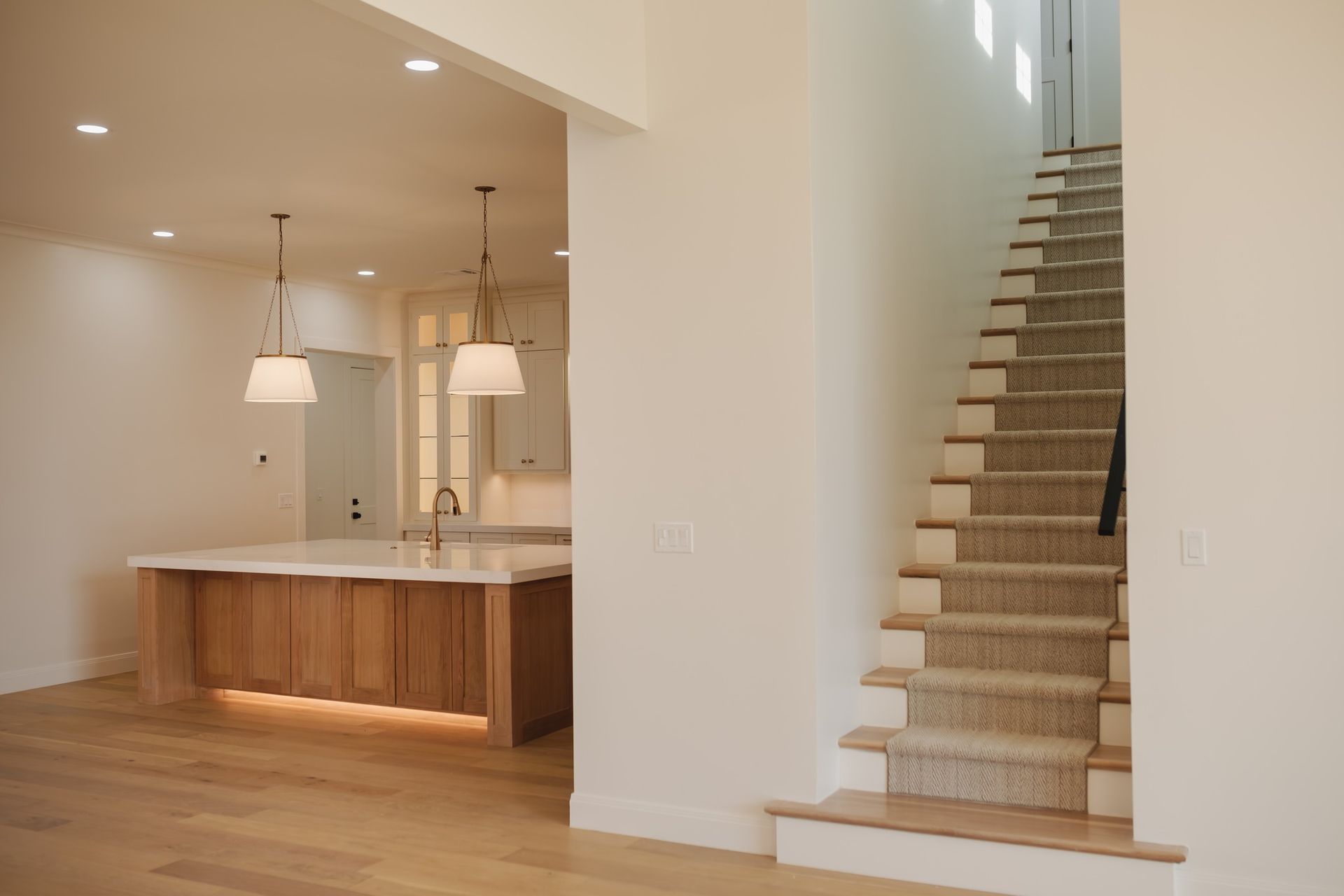 A kitchen and stairs in an empty house