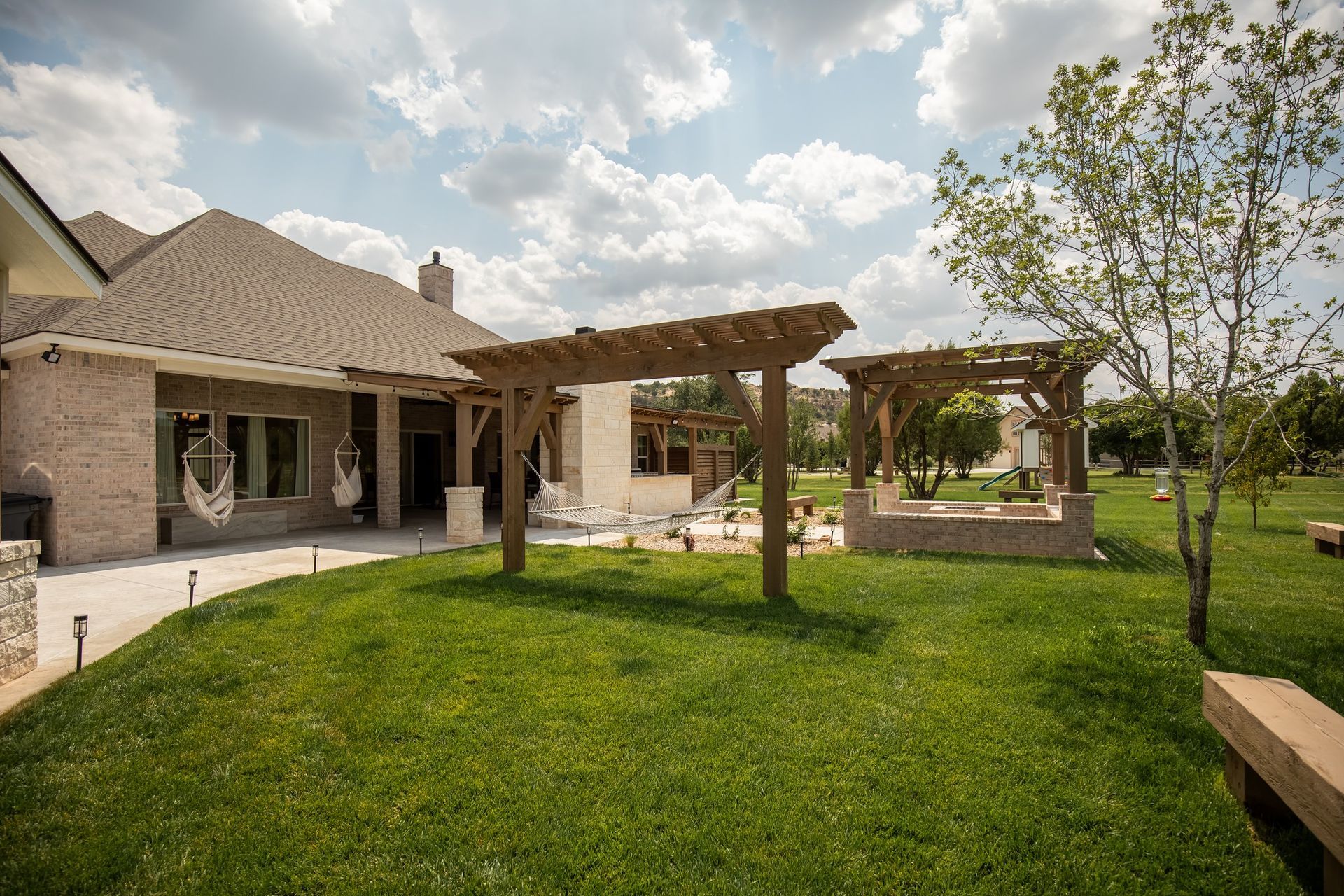 A house with a pergola in the backyard of it.