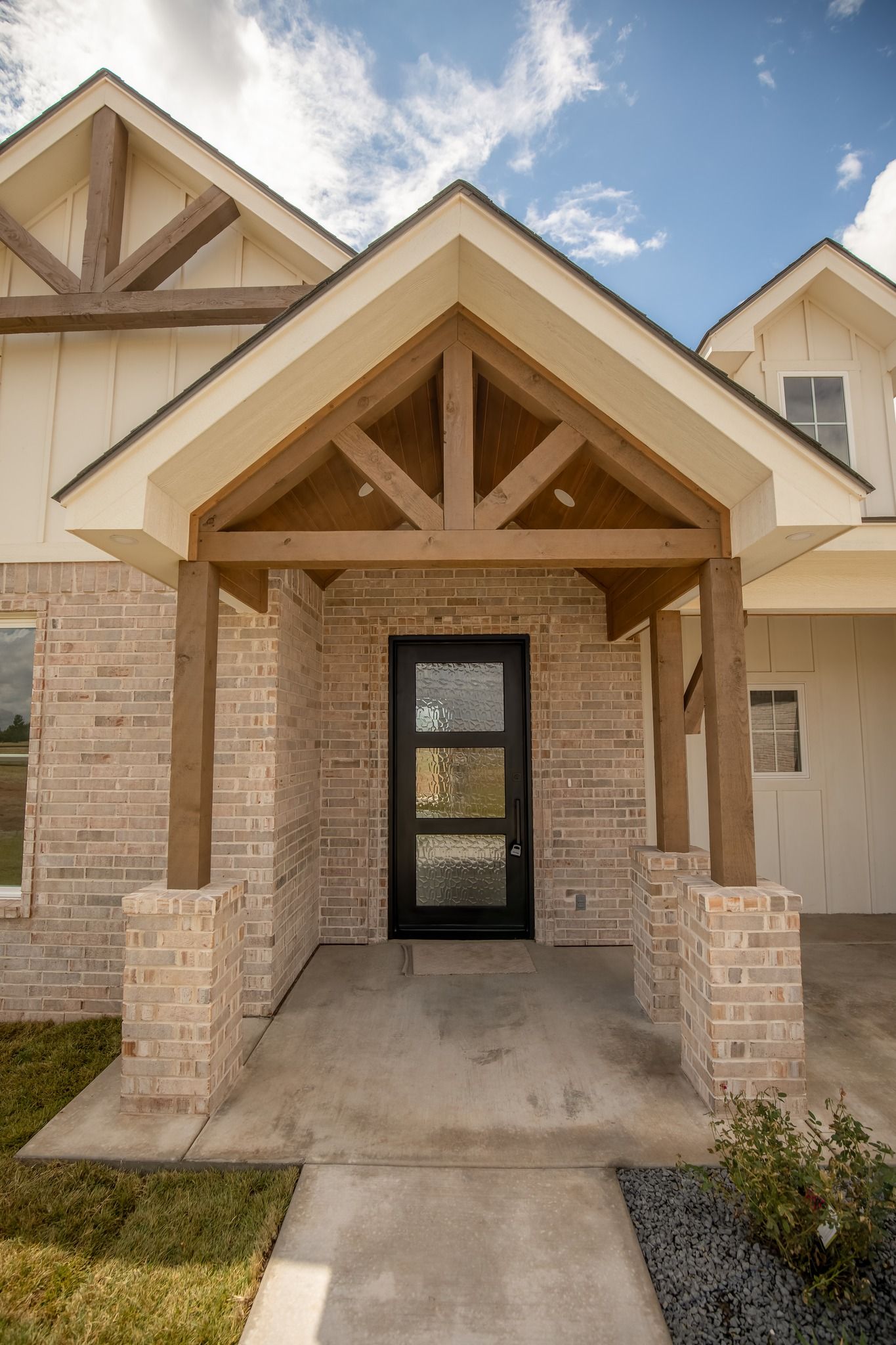 A brick house with a porch and a black door