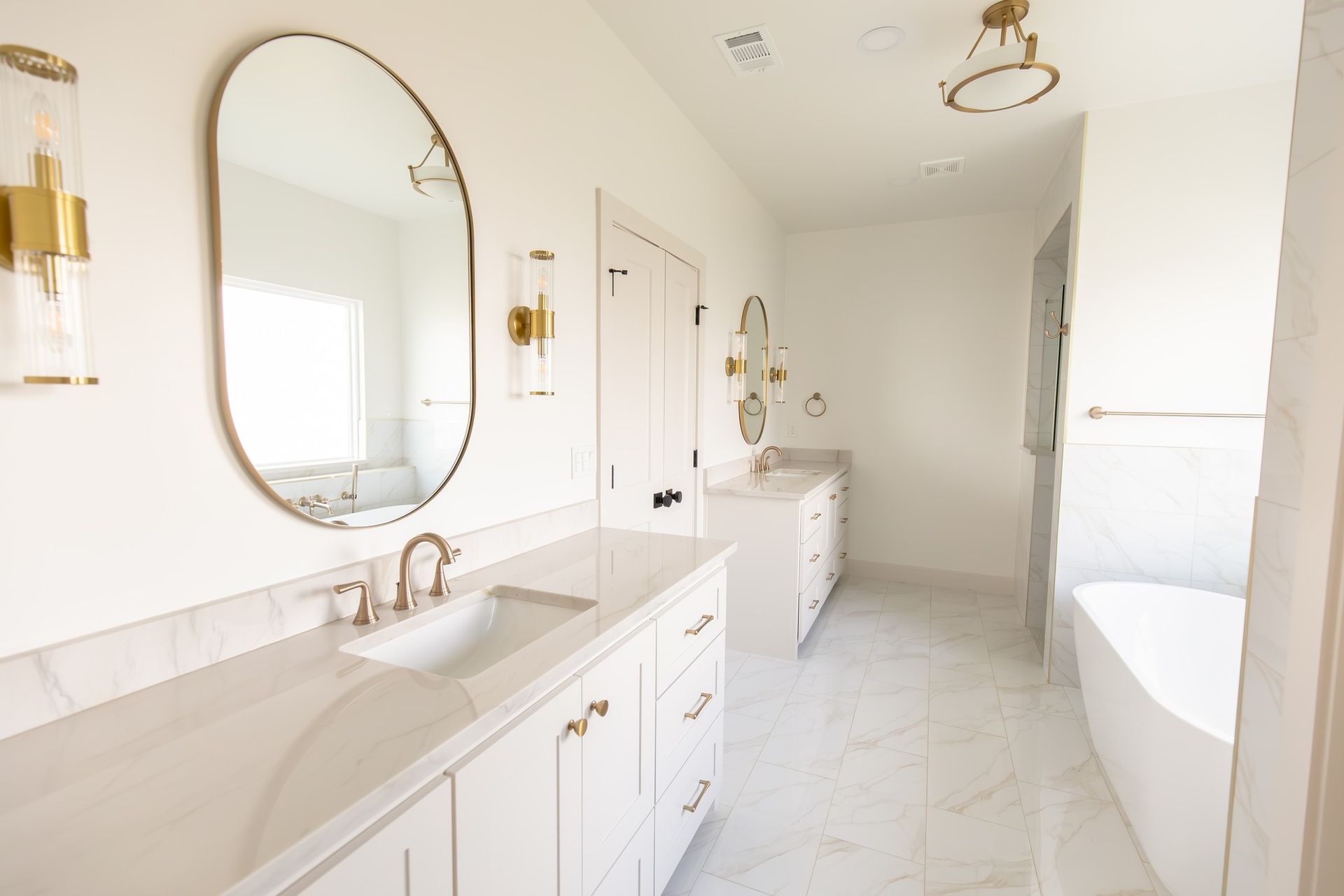 A bathroom with two sinks , two mirrors , and a bathtub.
