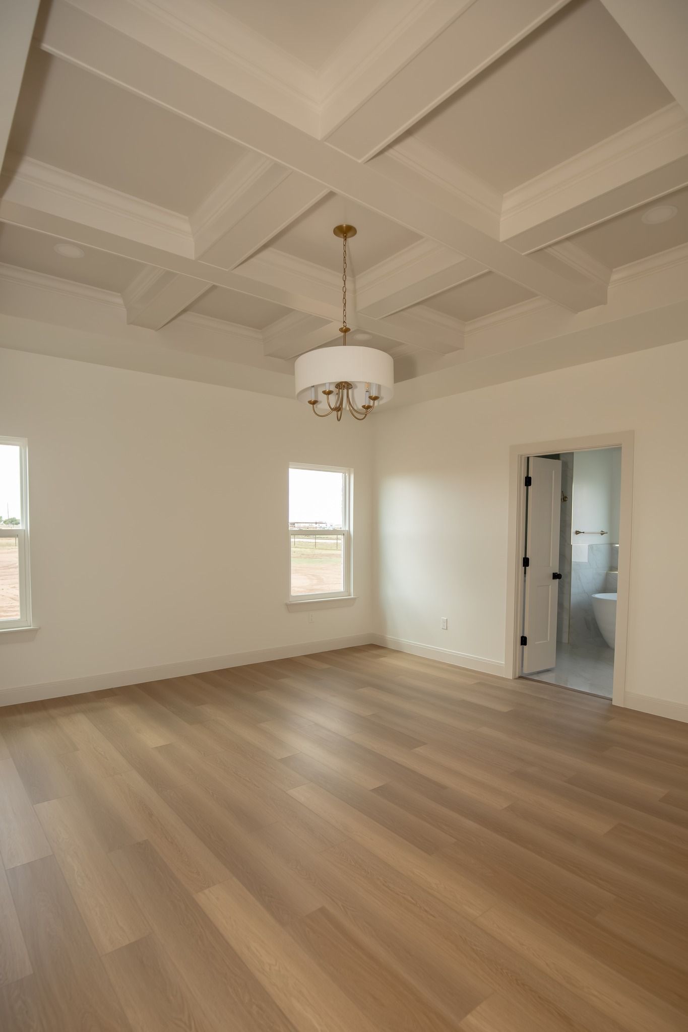 There is a chandelier hanging from the ceiling in the middle of the room.