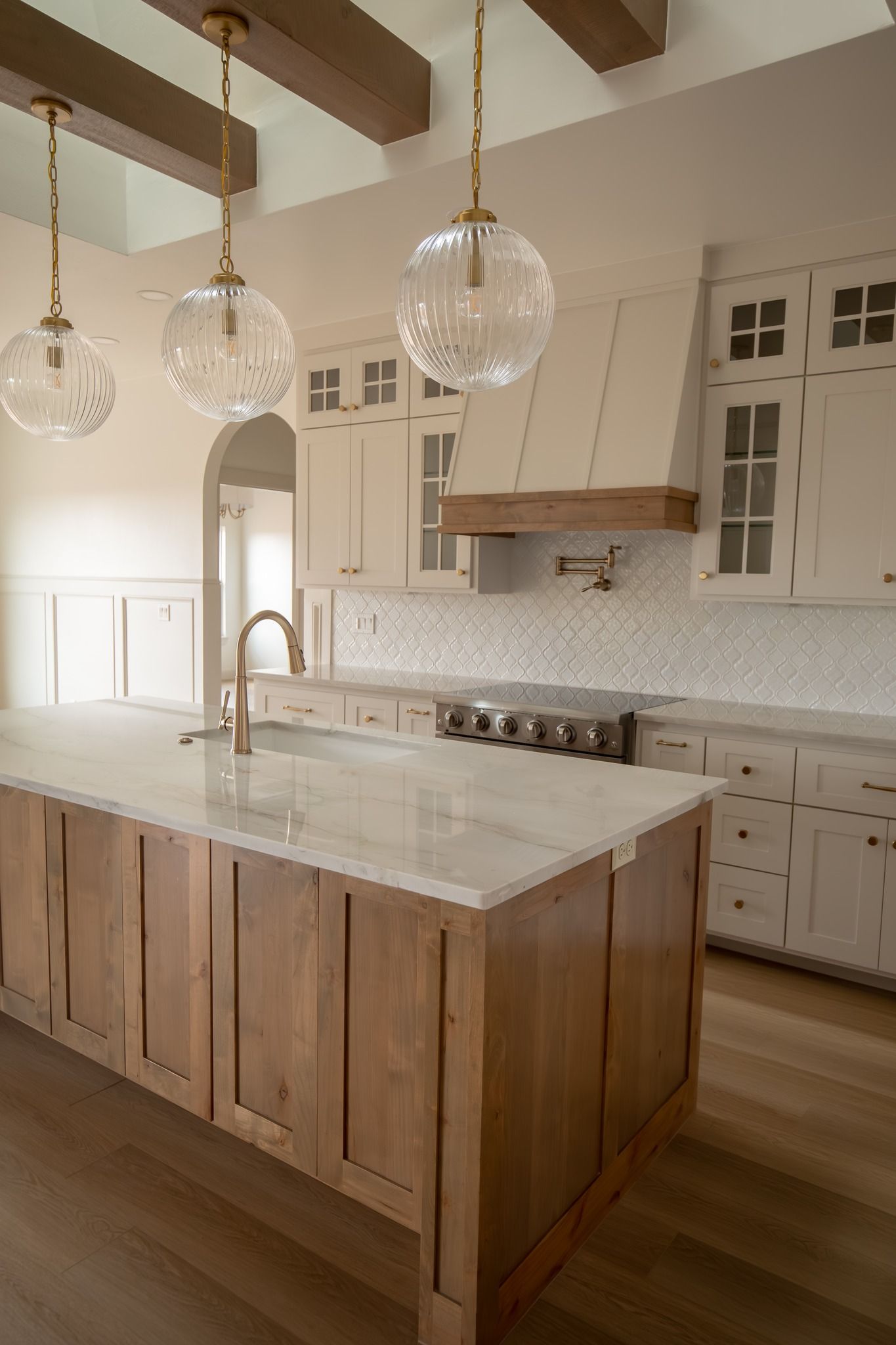 A kitchen with white cabinets and a large island in the middle.