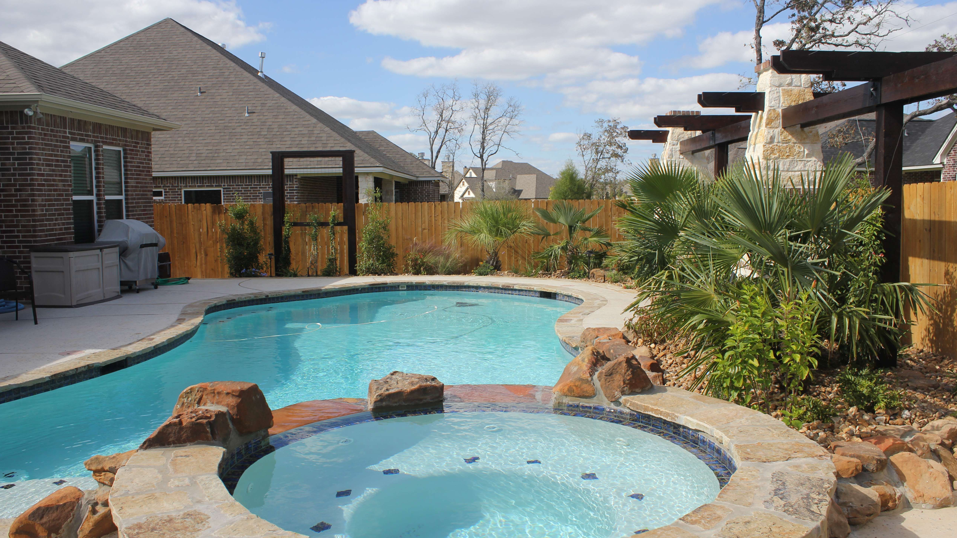 A large swimming pool with a hot tub in the middle of it