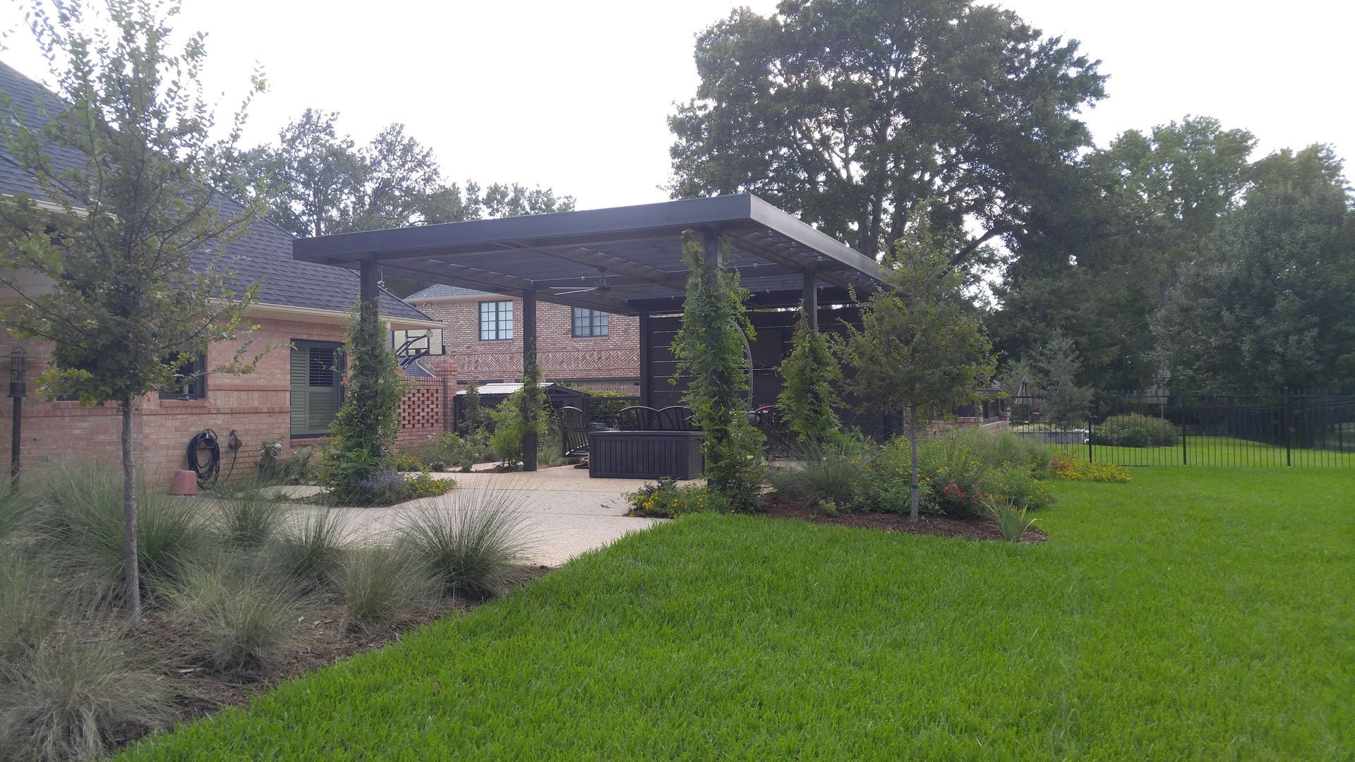 There is a pergola in the backyard of a house.