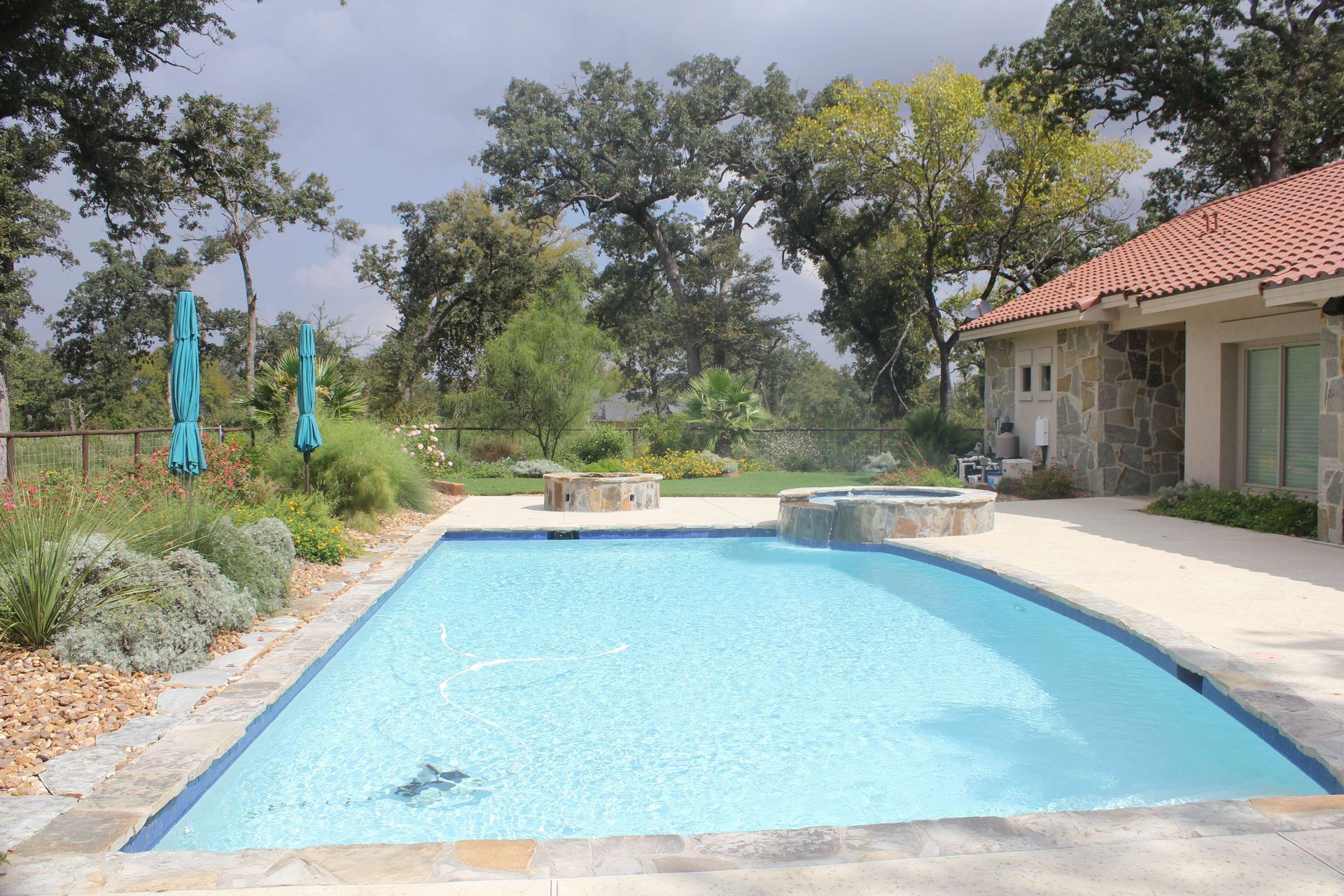 A large swimming pool with a house in the background