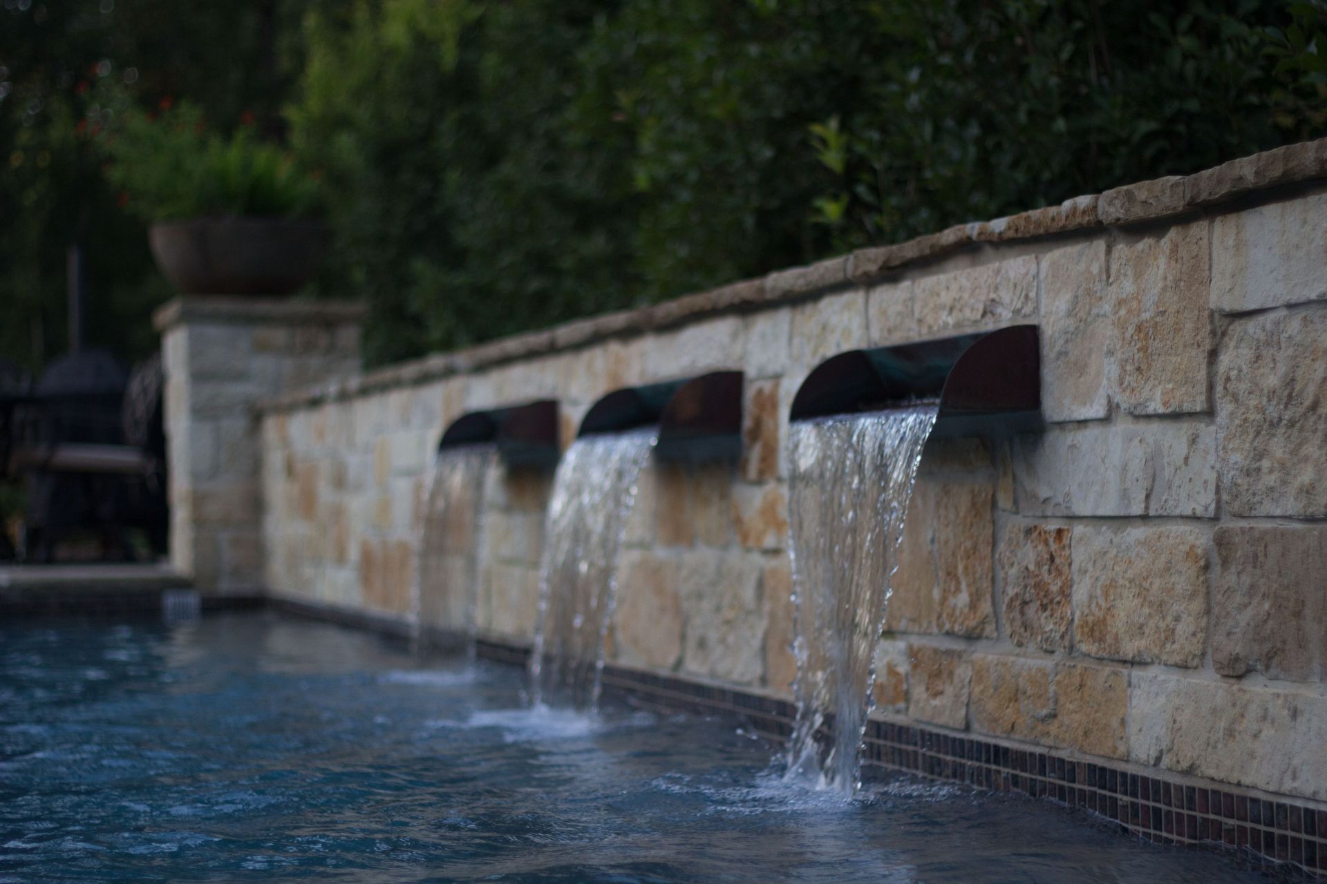 A swimming pool with a waterfall on the side of it.