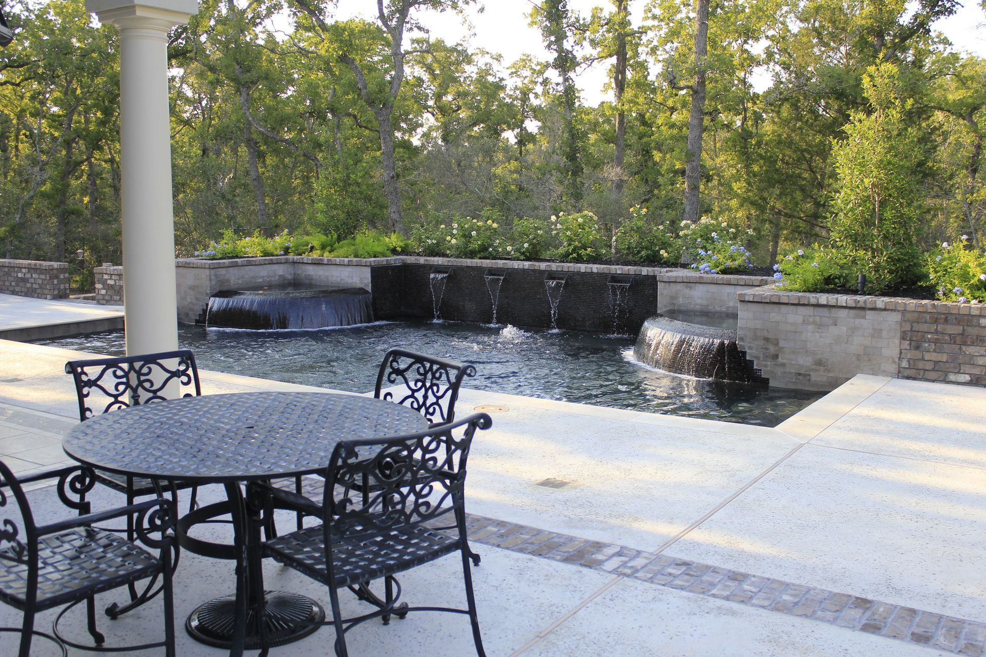 A table and chairs in front of a swimming pool