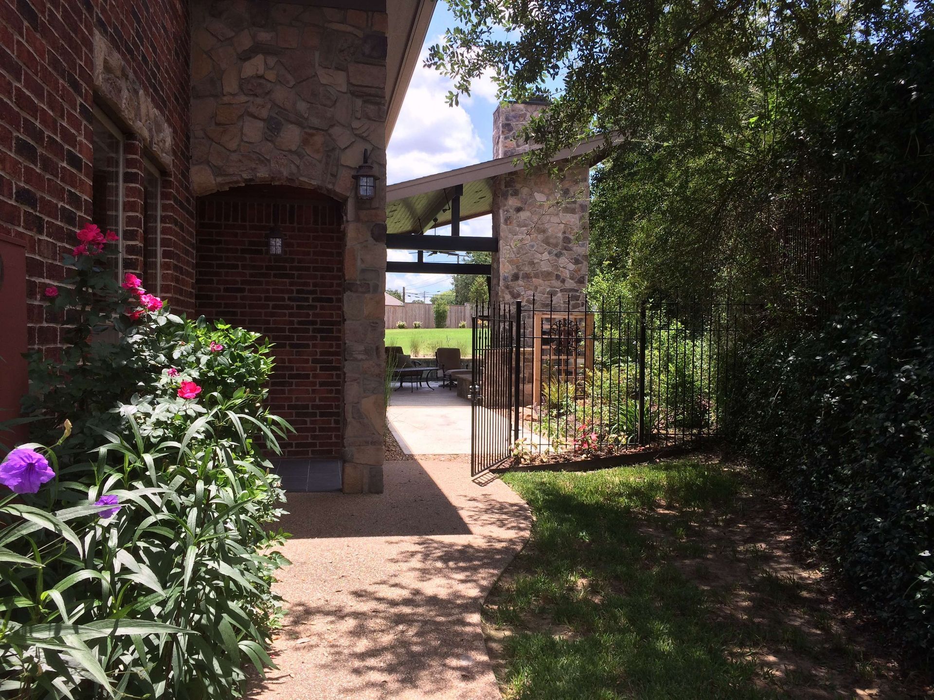 A brick building with a fence and flowers in front of it