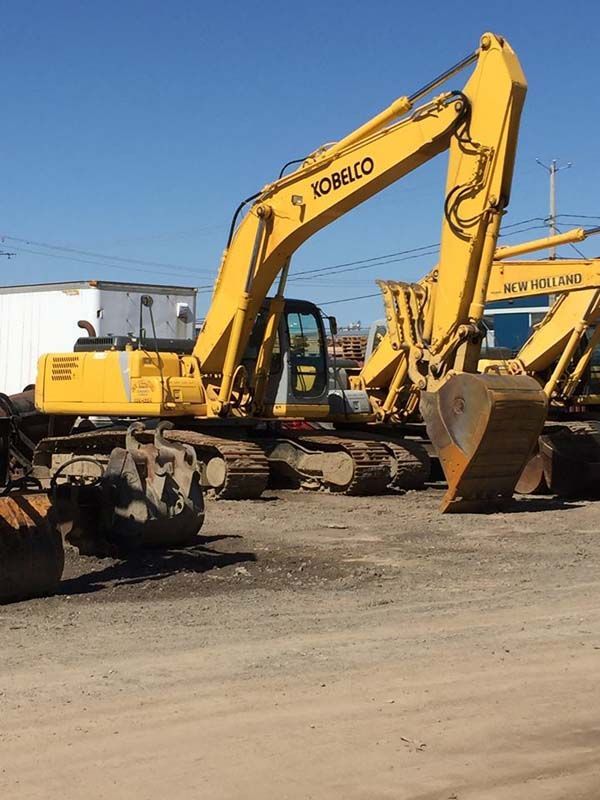 Une pelle kobelco est garée dans un parking