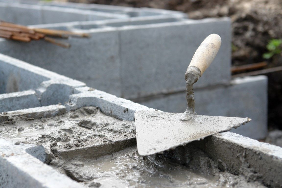 Cement blocks with mortar and trowel; construction site.