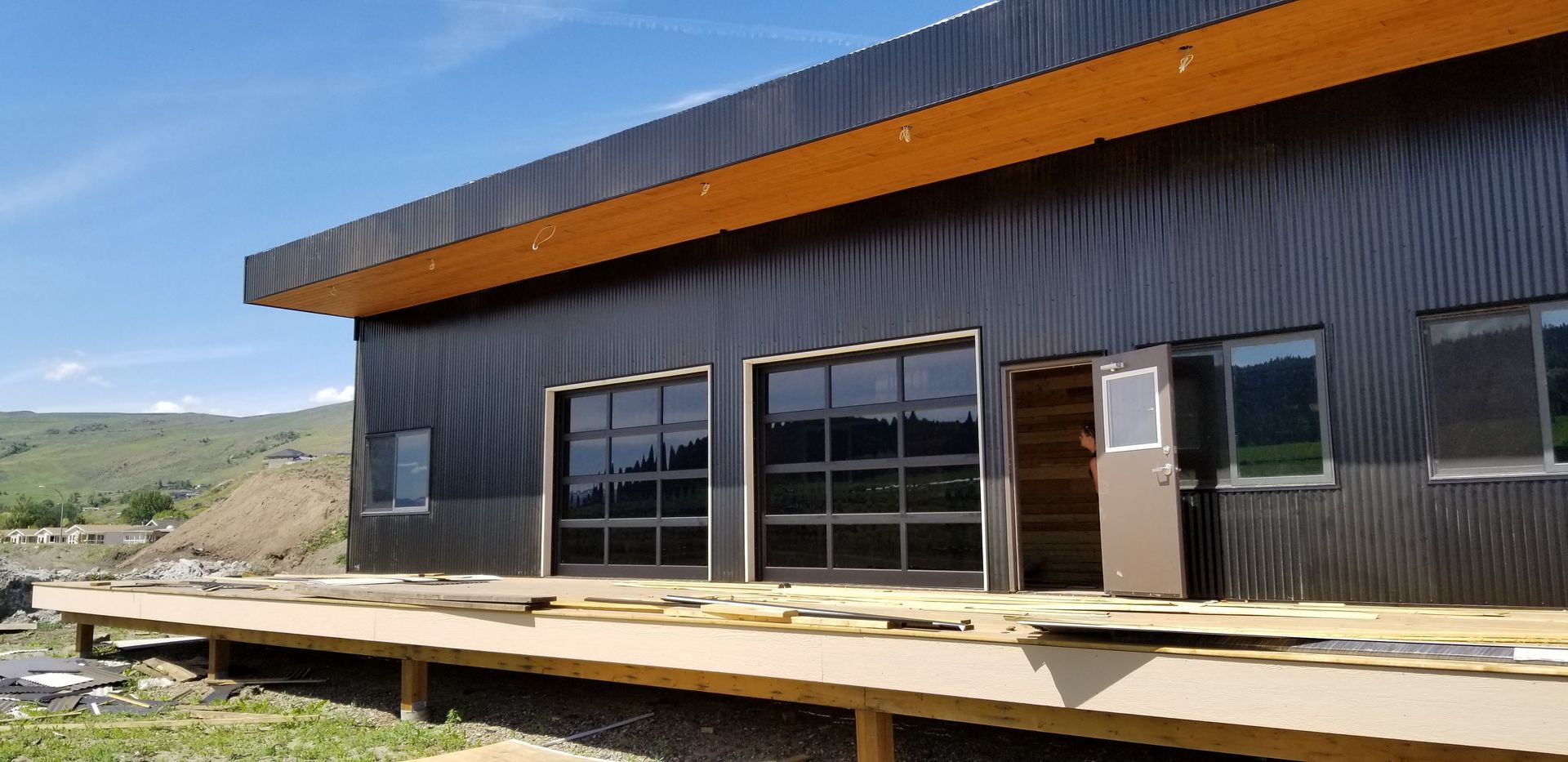 A large black building with a wooden deck in front of it.