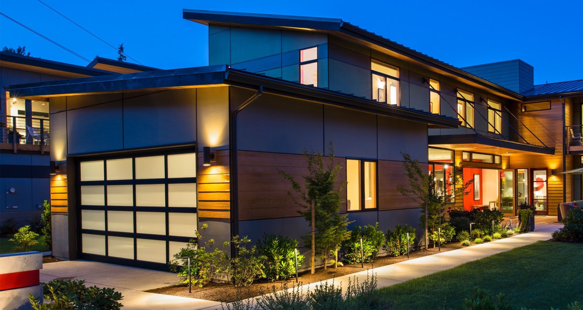 A large house with a garage door is lit up at night.