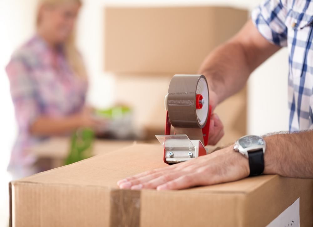 Man Taping a Cardboard Box — JR Removals Mackay in Dysart, QLD
