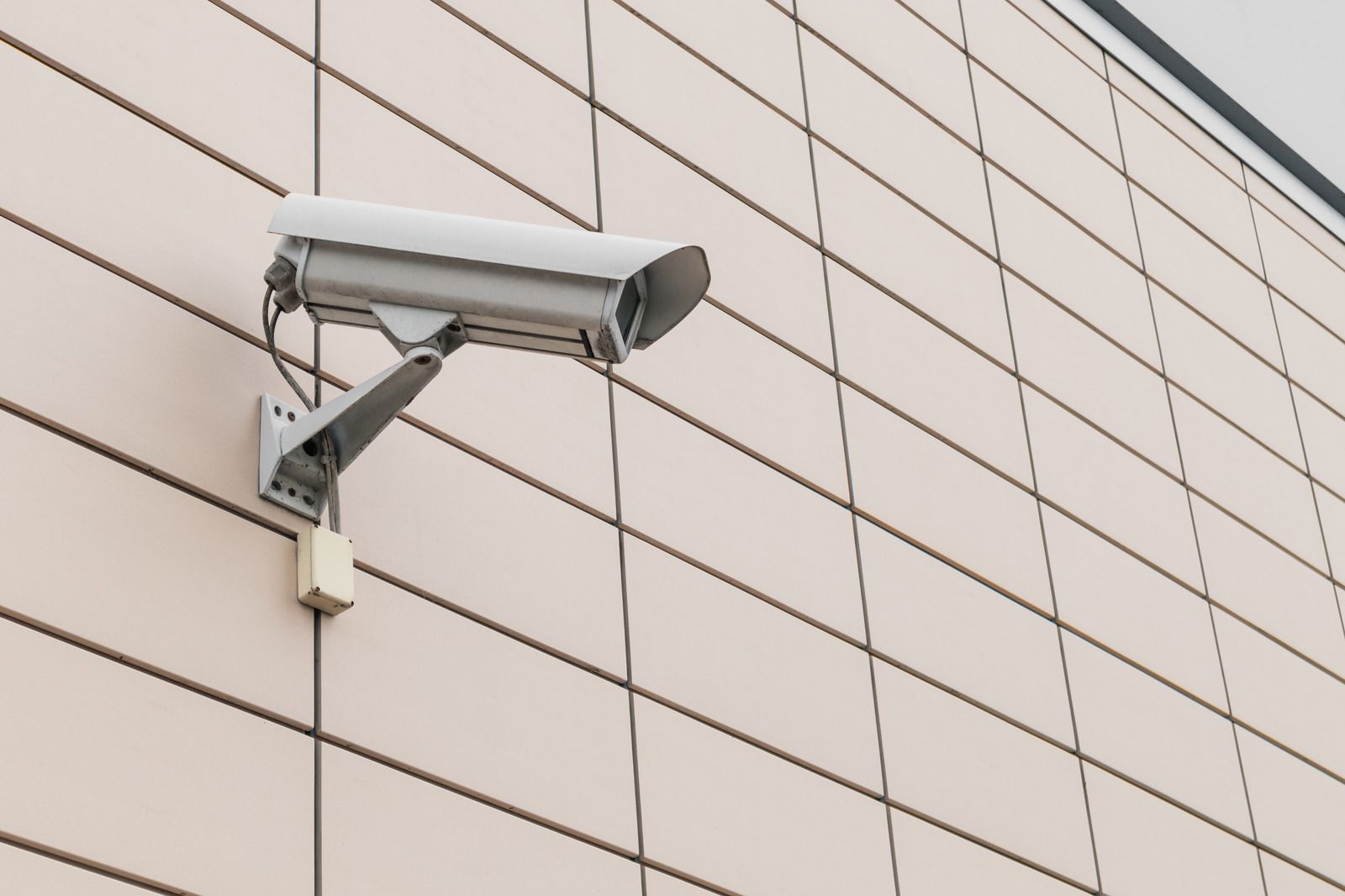 A security camera is mounted on the side of a building.