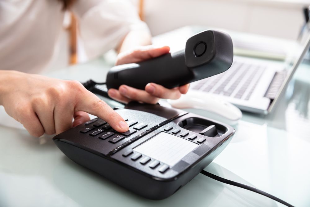 Woman Handling Dialing Telephone Number — Telecommunications in Noosaville, QLD