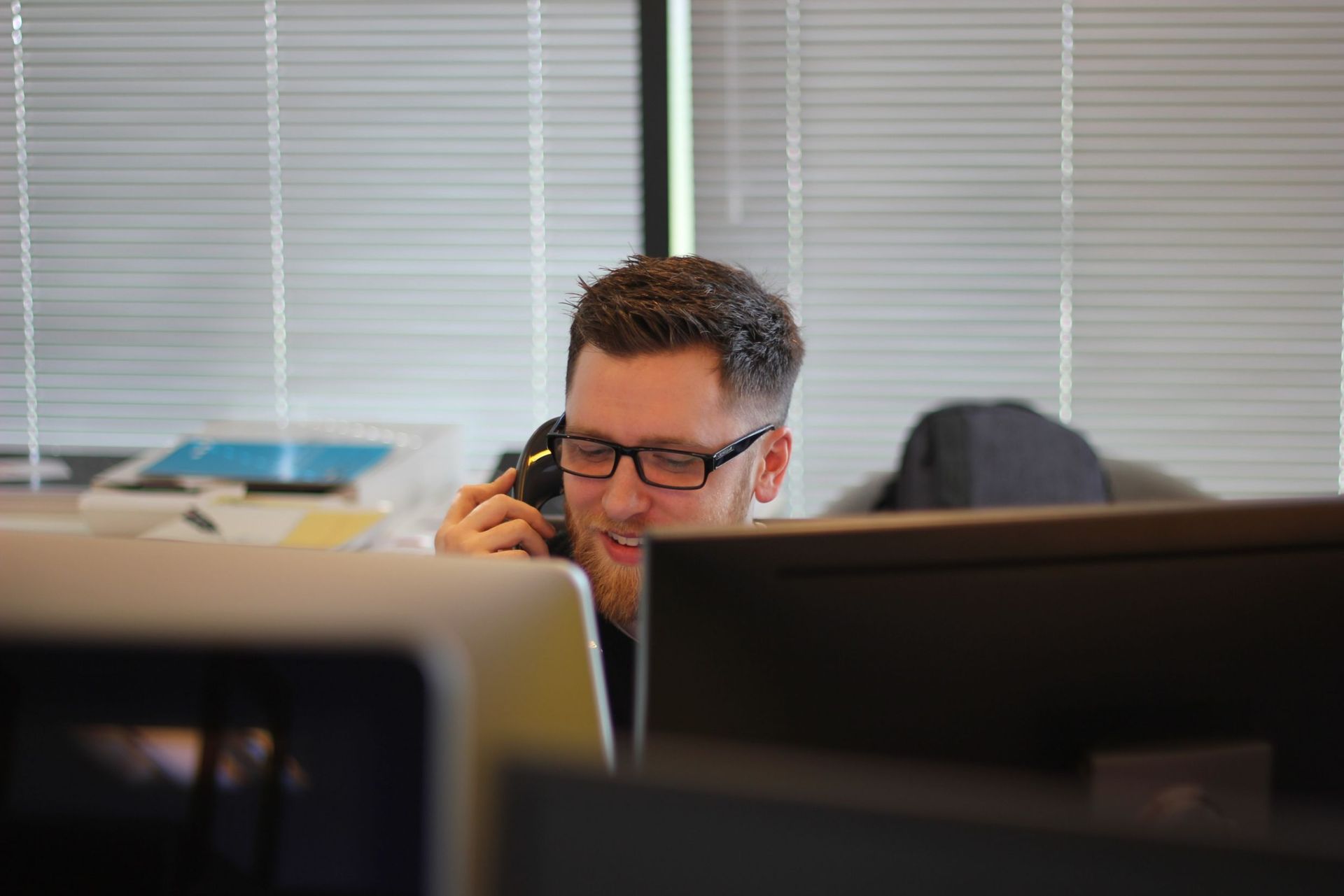 A Man Holding a Phone While Answering a Call — Telecommunications in Noosaville, QLD