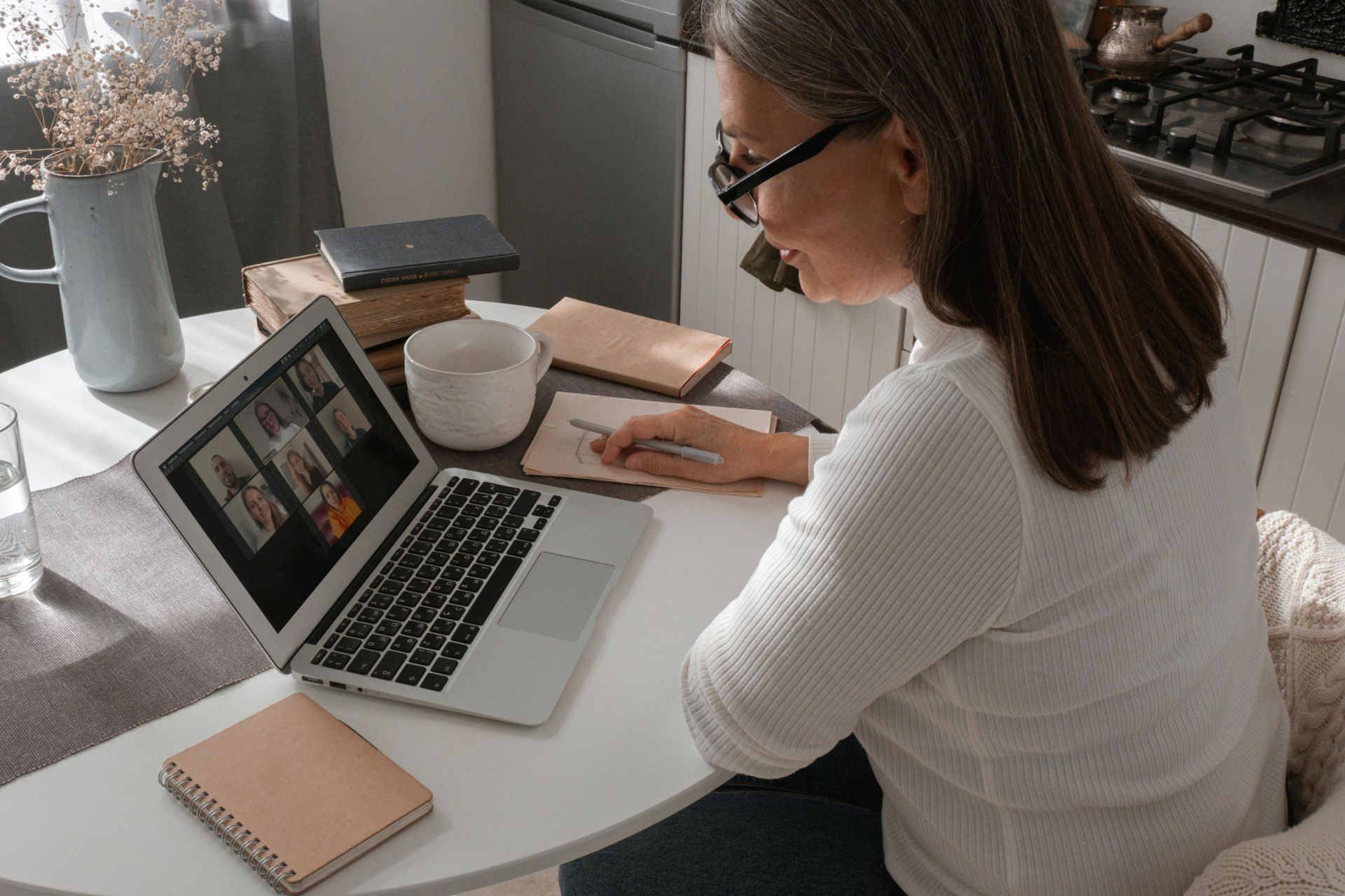 A woman is sitting at a table using a laptop computer.