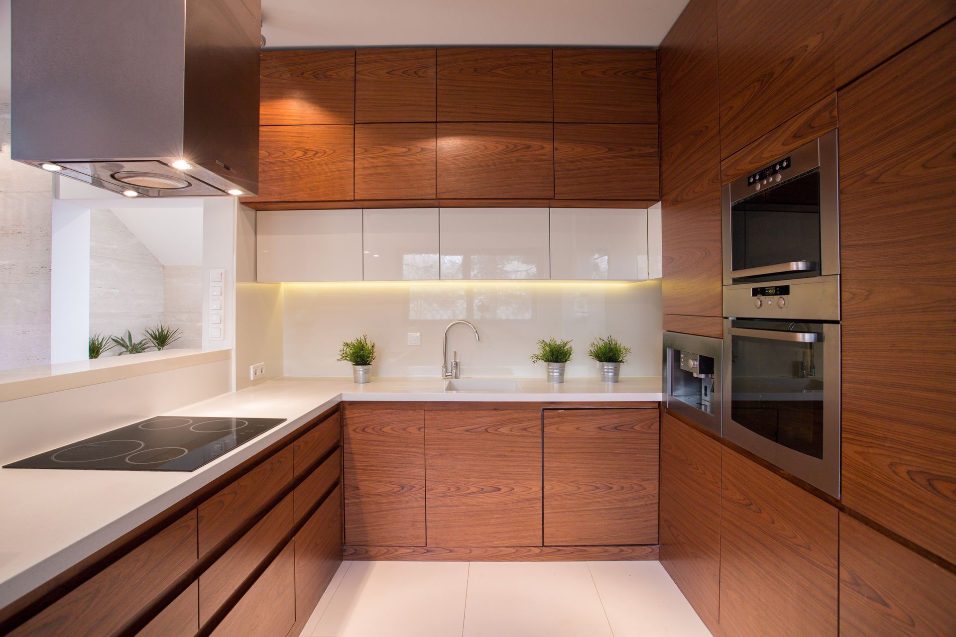 A kitchen with wooden cabinets , stainless steel appliances , and a stove top oven.