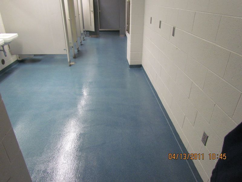 Blue floor hallway with white walls, and a line of electrical outlets.