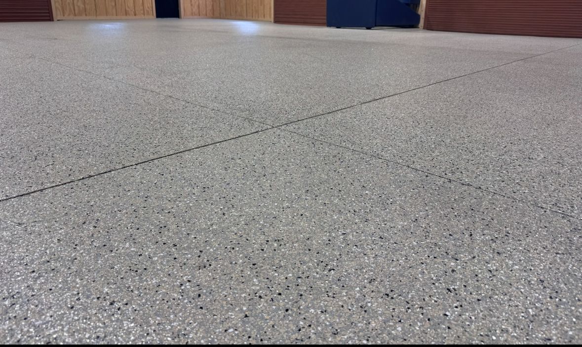 Indoor cafe area with round tables, chairs, brick walls, and red pendant lights.