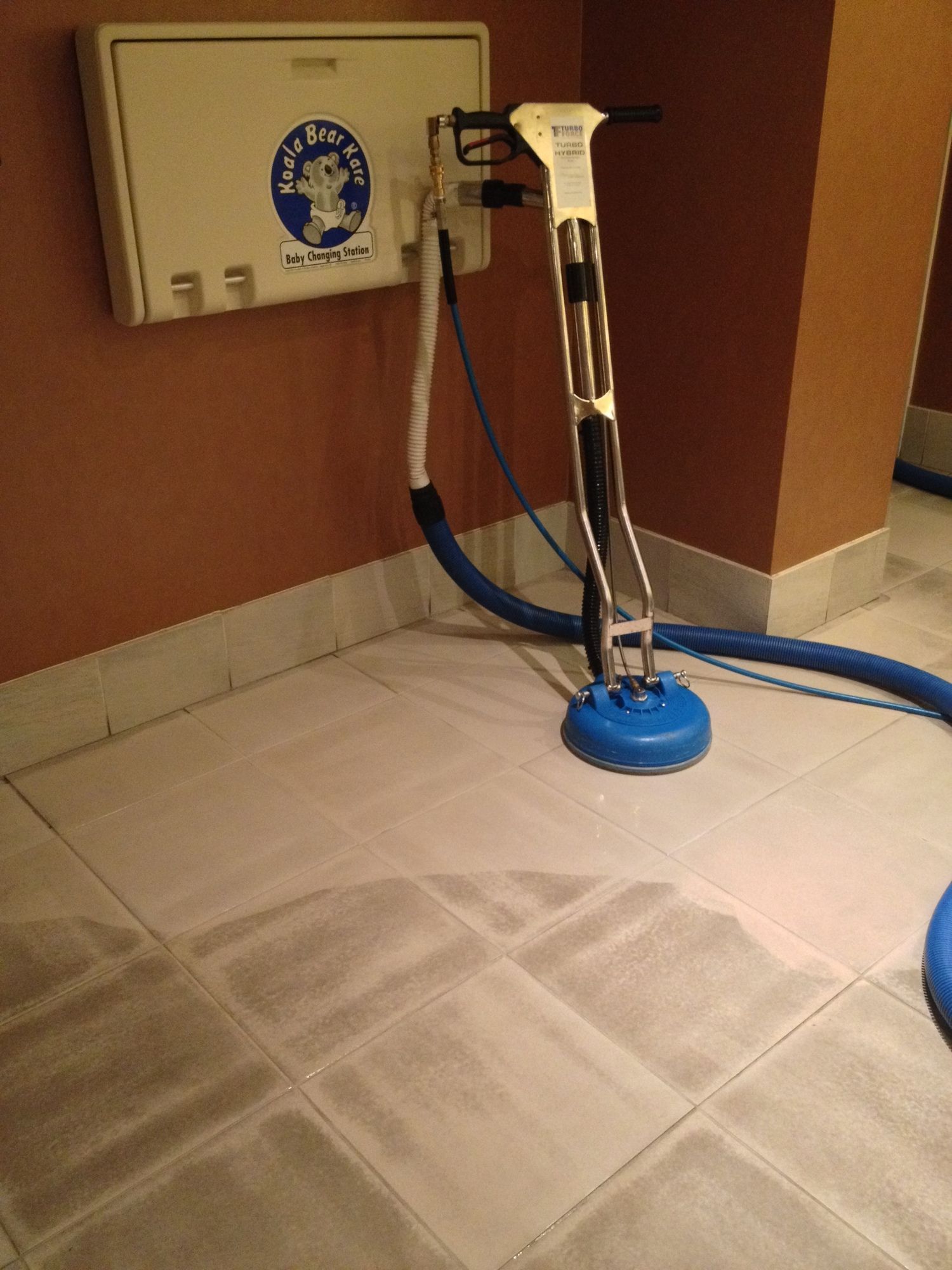 A vacuum cleaner is sitting on a tiled floor in a room.