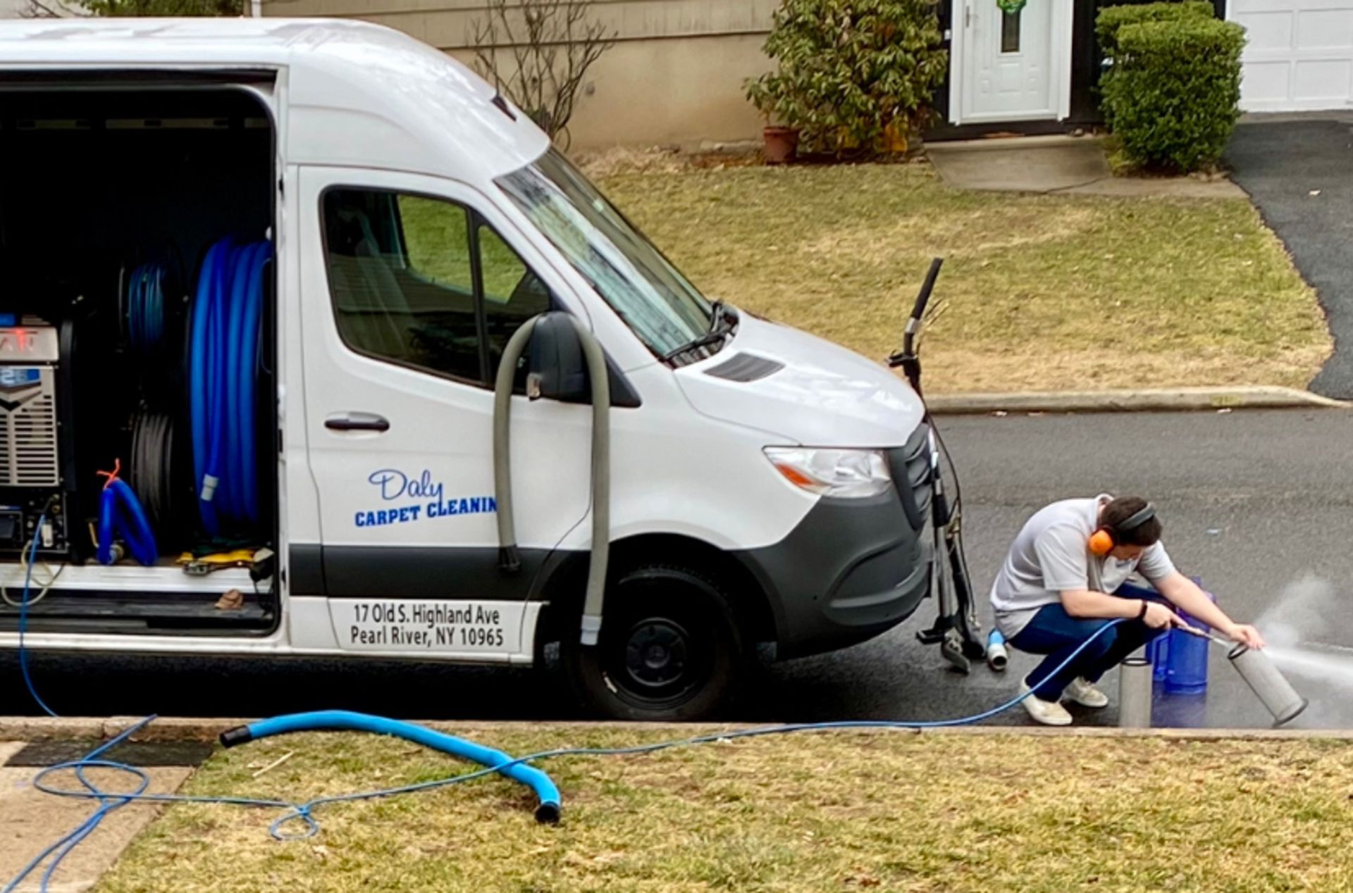 A man is kneeling in front of a white van.