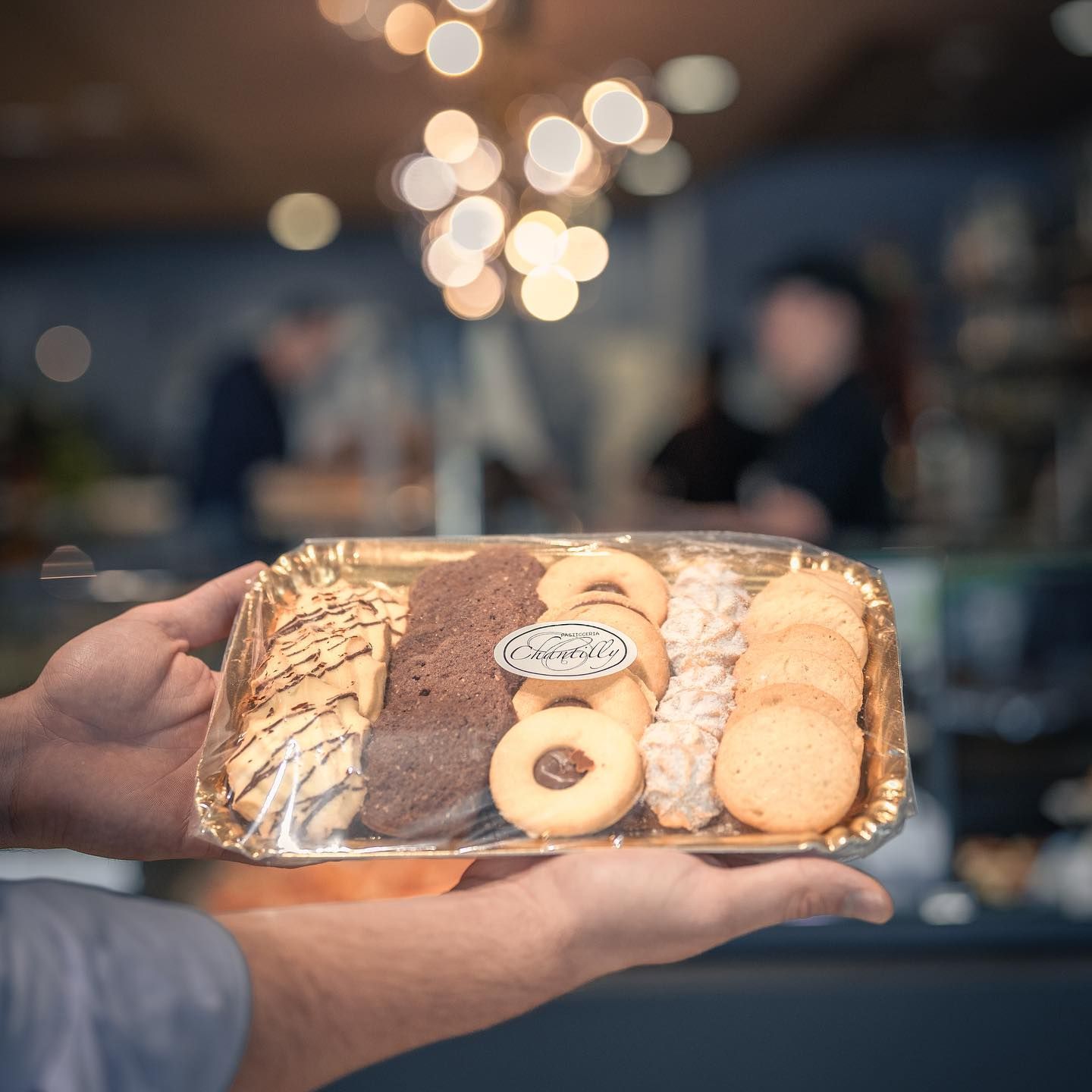 Un tavolo apparecchiato per un ricevimento di nozze con piatti, bicchieri da vino, posate e candele.