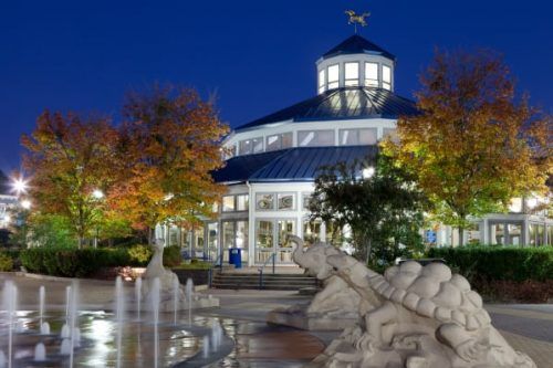 A fountain in front of a building at night