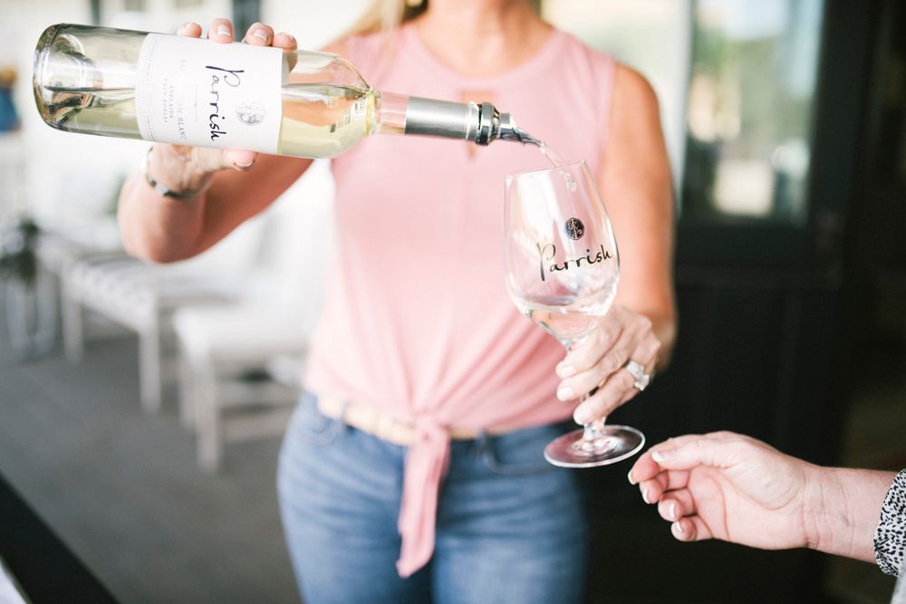 Pouring wine from a bottle into a stemmed Parrish Family Vineyard glass at the Tasting Room in Paso