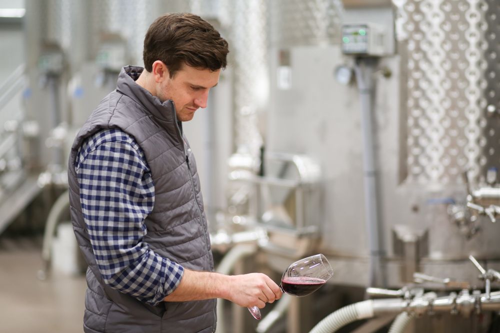 Winemaker Cody Alt holding Parrish Family Vineyard Silken wine in the winery at 3590 Adelaida Road, Paso Robles, CA 93446. 