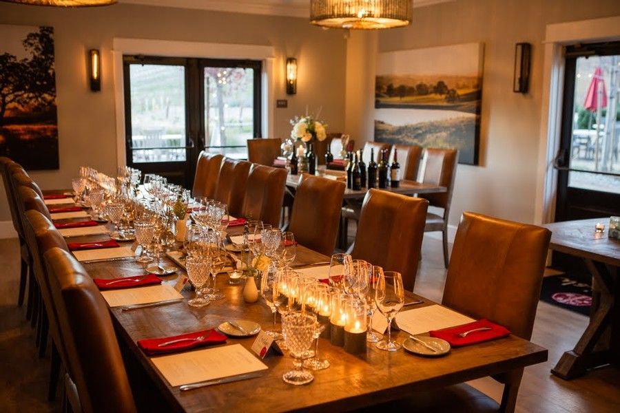 A long table with a lot of glasses and candles on it in a dining room.