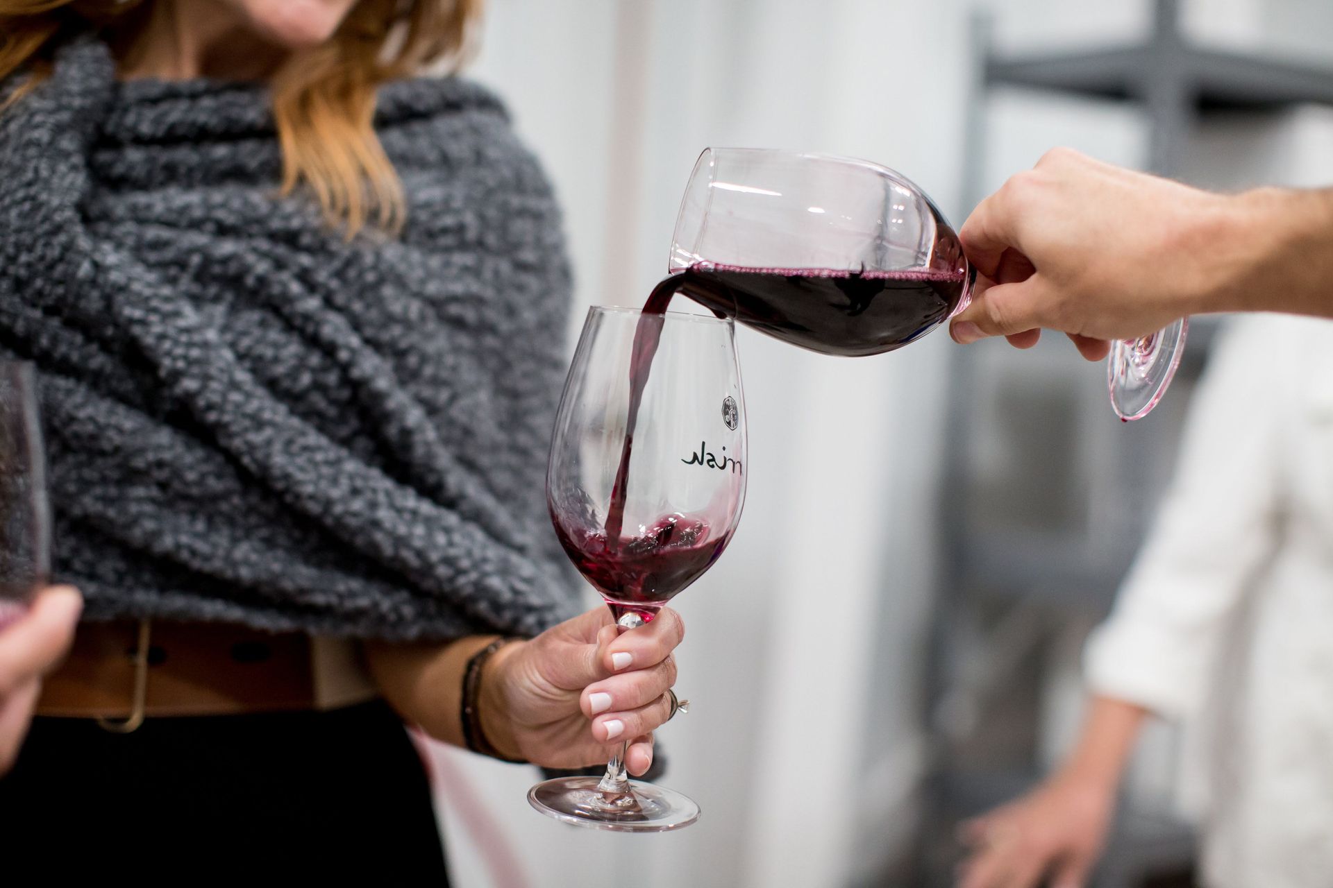 Pouring red wine from one glass to another.