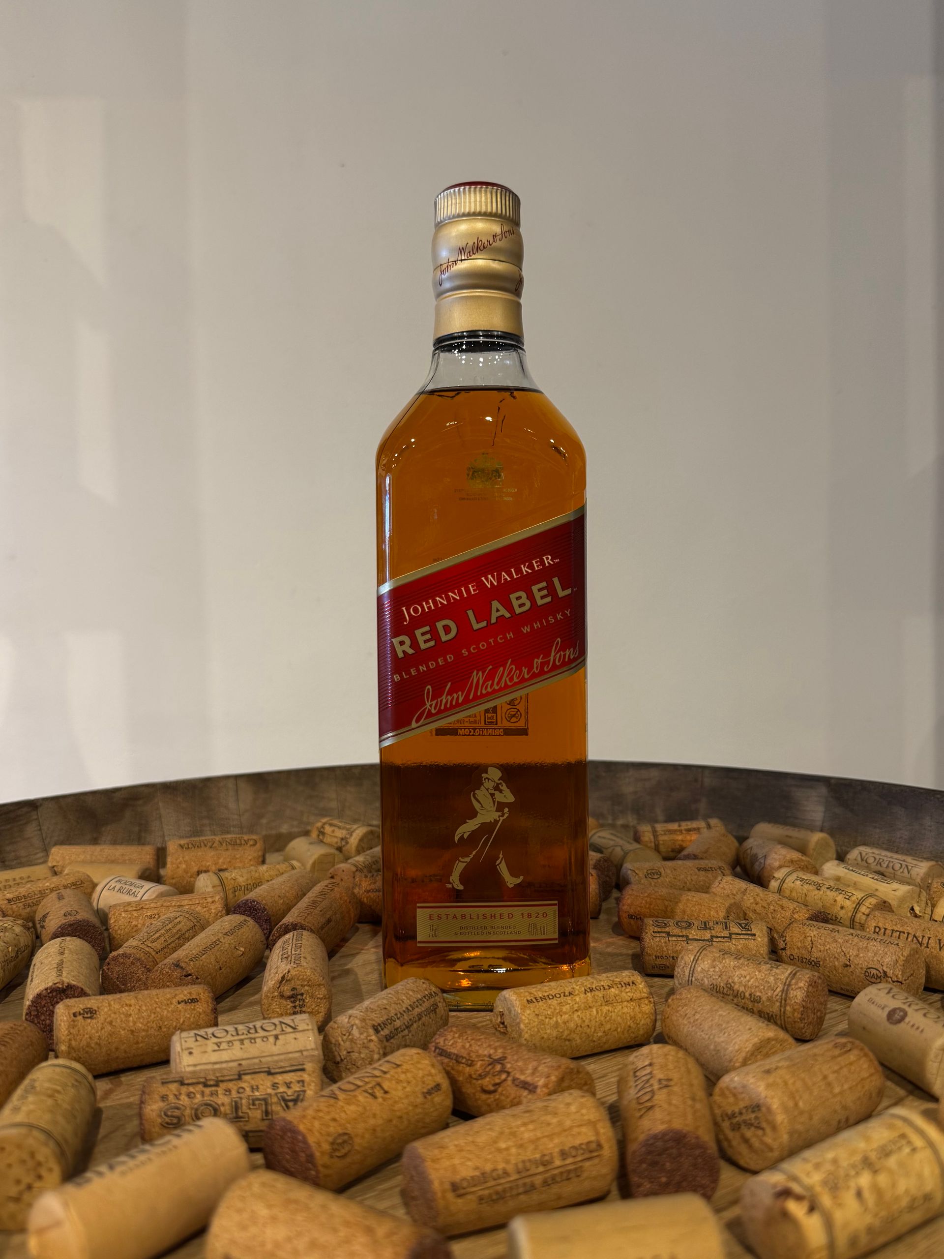 Botella de Johnnie Walker Red Label sobre una pila de corchos.