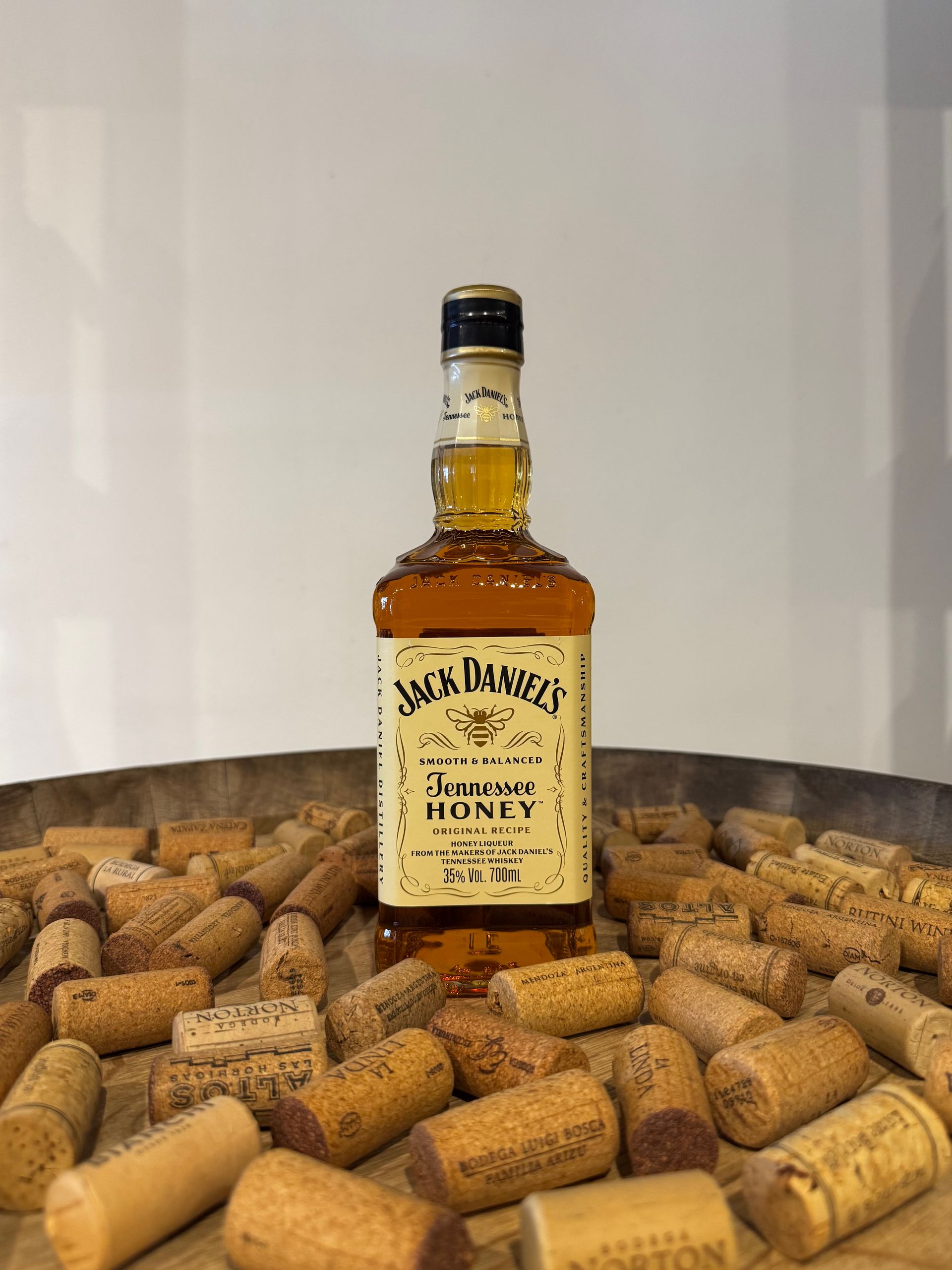 Botella de whisky Jack Daniel's con corchos dentro de un recipiente de madera.