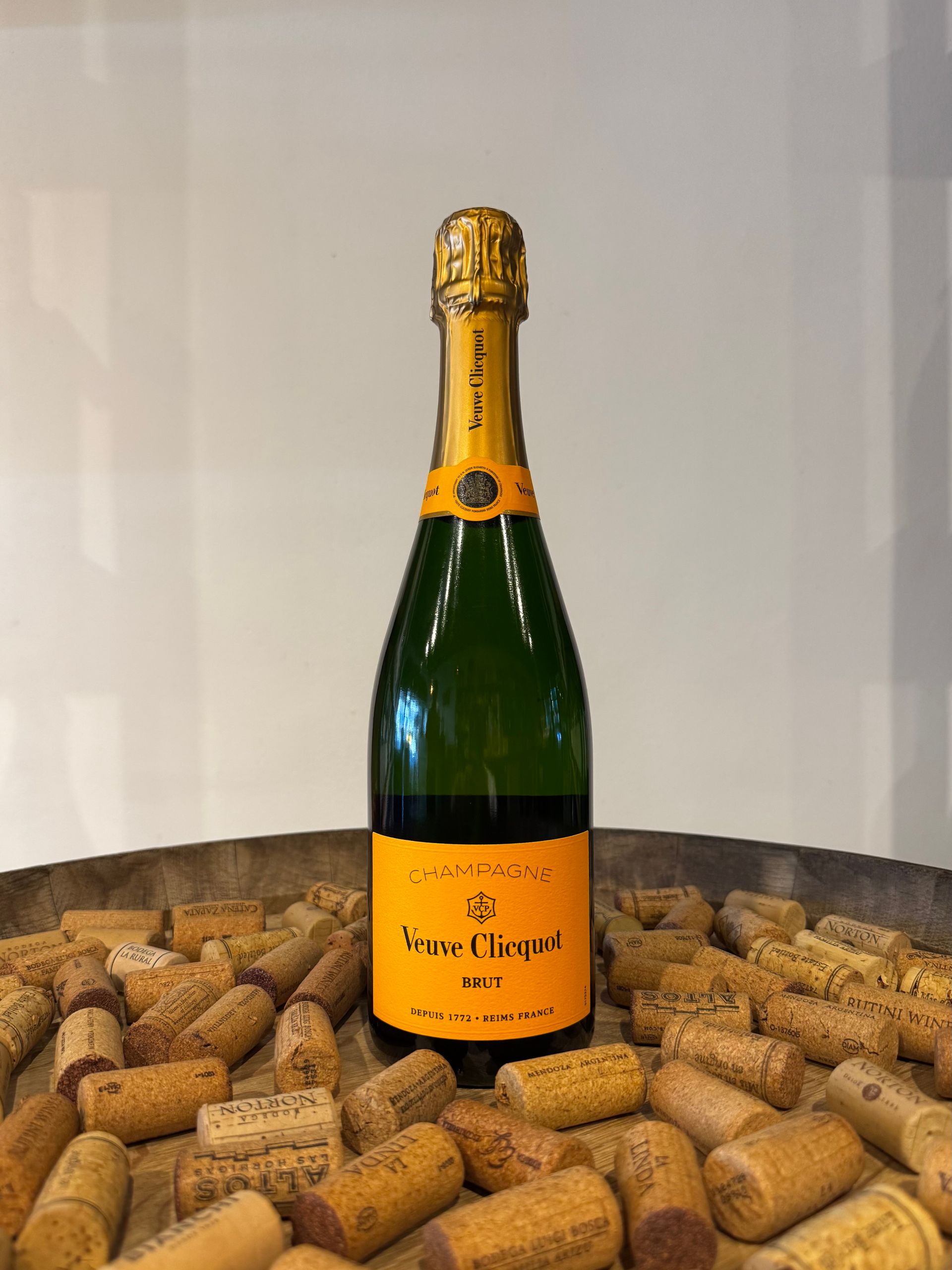 Botella de champán Veuve Clicquot sobre un lecho de corchos, colocada sobre una bandeja de madera.