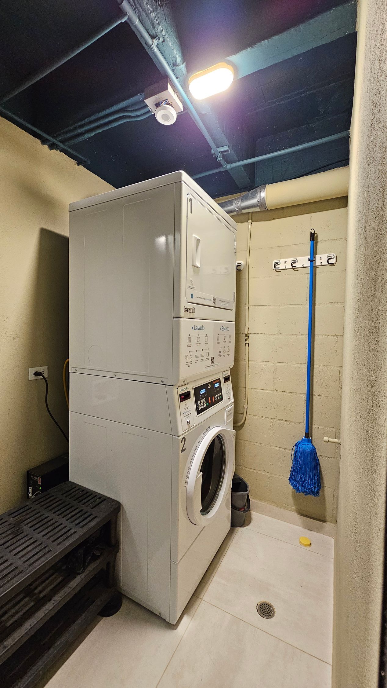 A washer and dryer are stacked on top of each other in a laundry room.