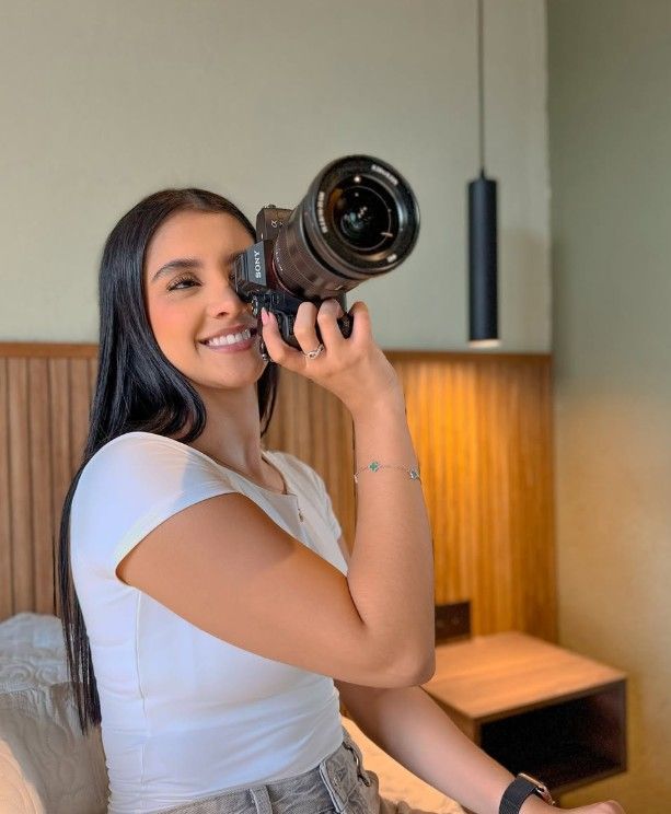 A woman is laying on a bed reading a book.