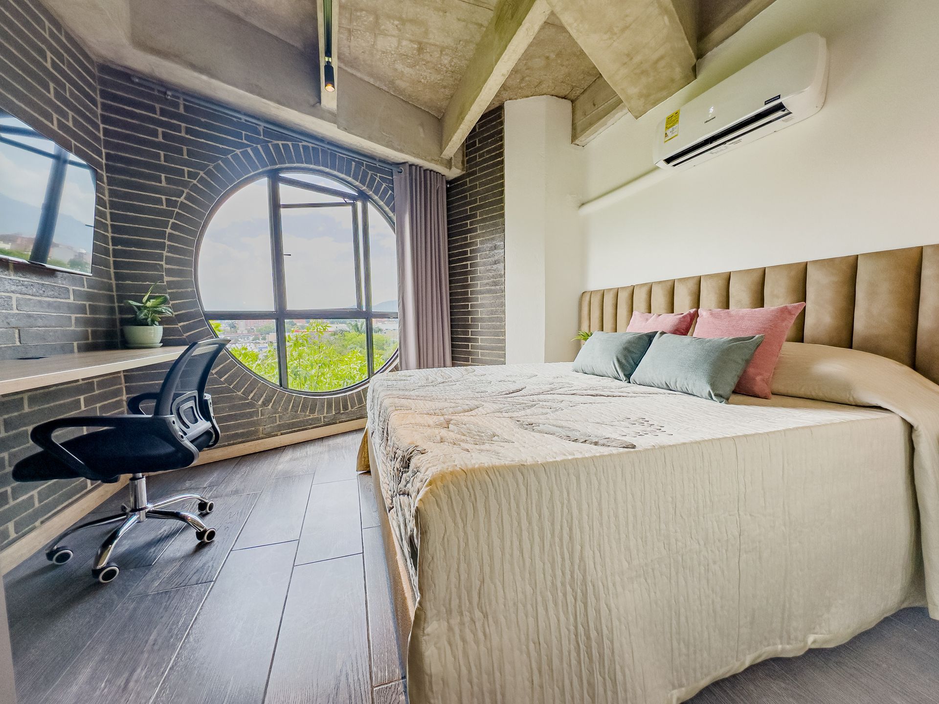 A bedroom with a large bed , desk and chair.