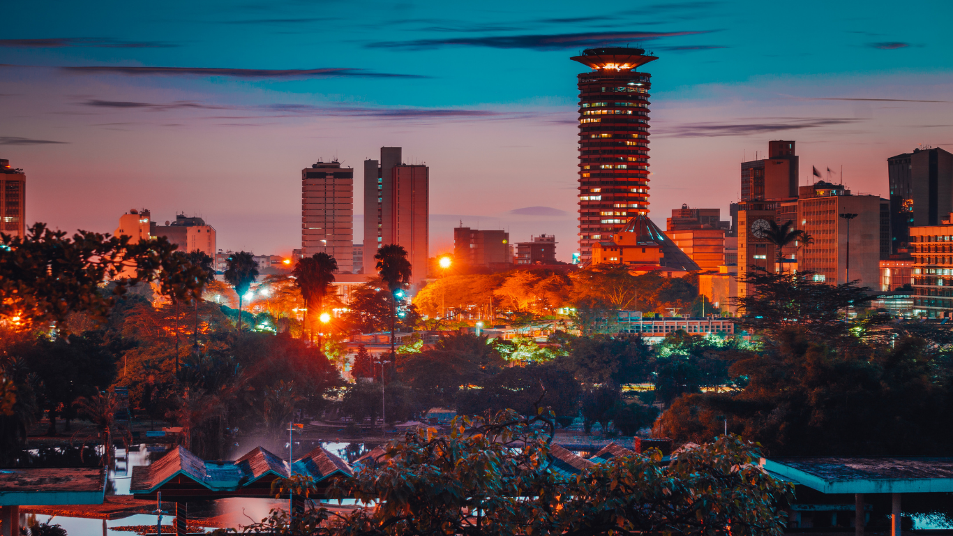 City skyline at dusk with lit buildings and colorful sky.