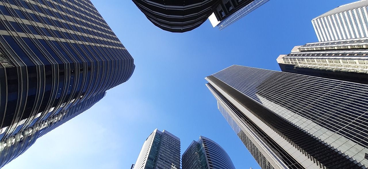 Low-angle shot of tall skyscrapers against a clear blue sky.