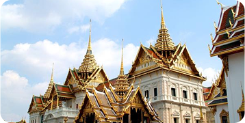 A large building with a lot of roofs and a blue sky in the background.