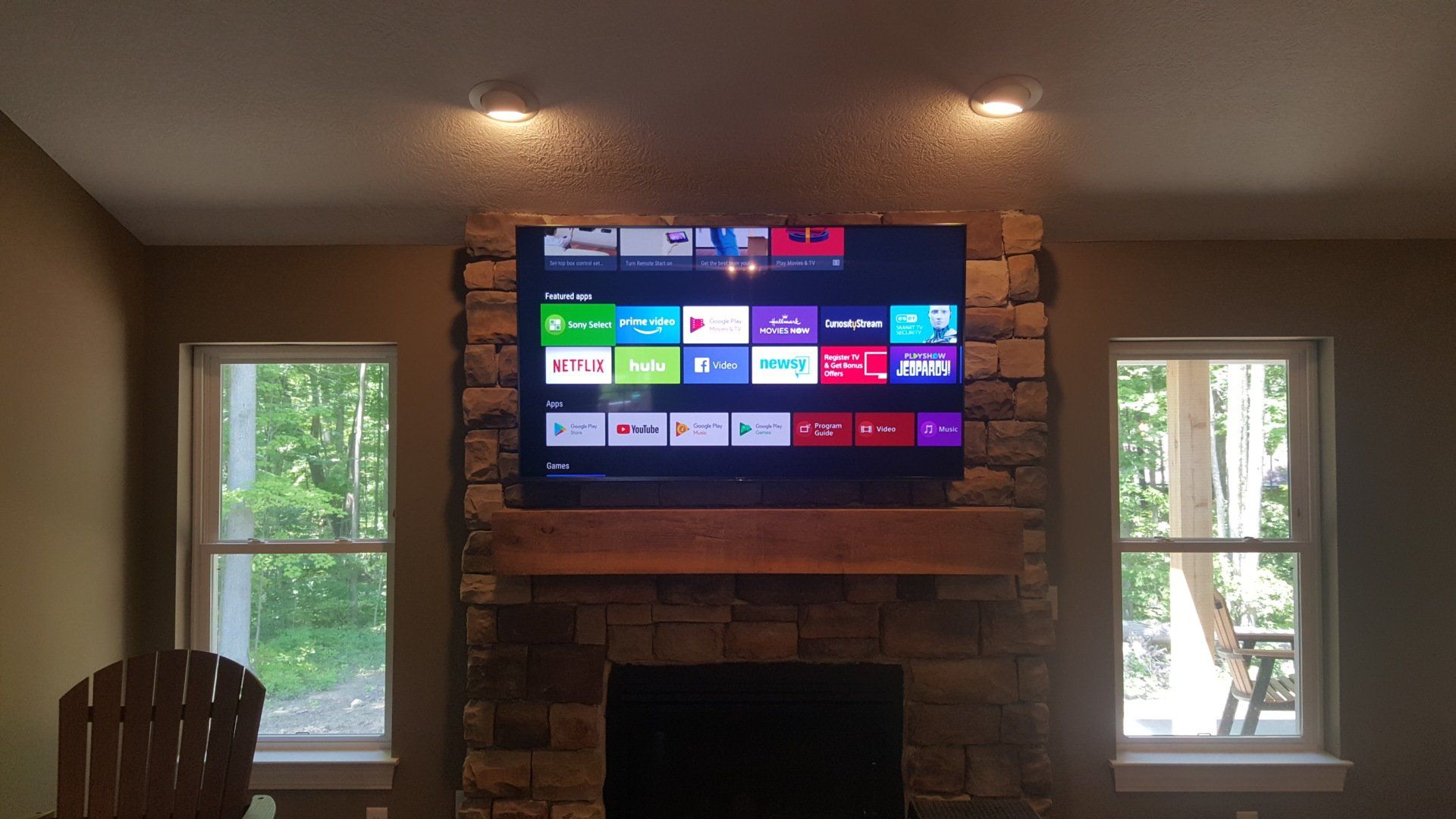 a flat screen tv is mounted above a stone fireplace in north central ohio