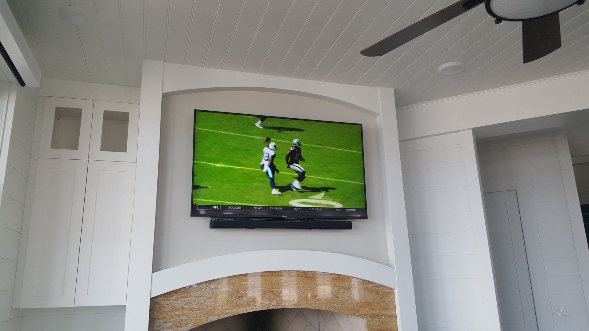 a flat screen tv and soundbar is mounted above a fireplace in avon ohio