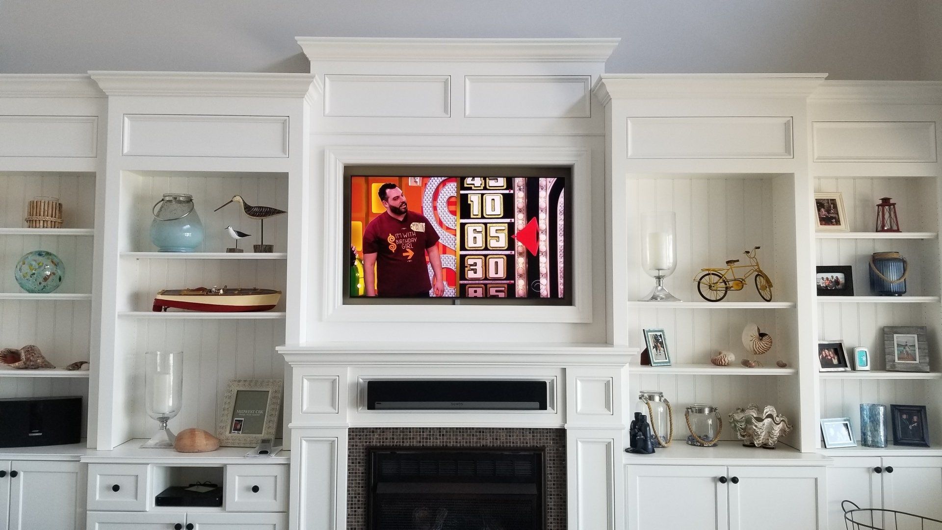A television mounted above a fireplace with a sonos soundbar installed by fisher electronics in northern ohio.