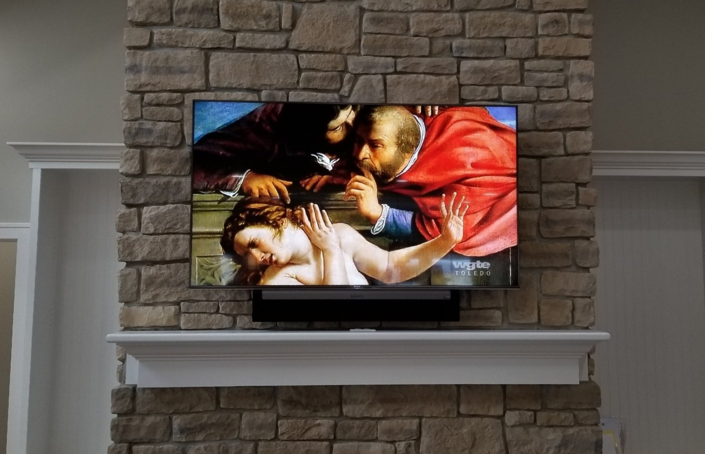 a flat screen tv is mounted to a fireplace with a sonos soundbar in north central ohio