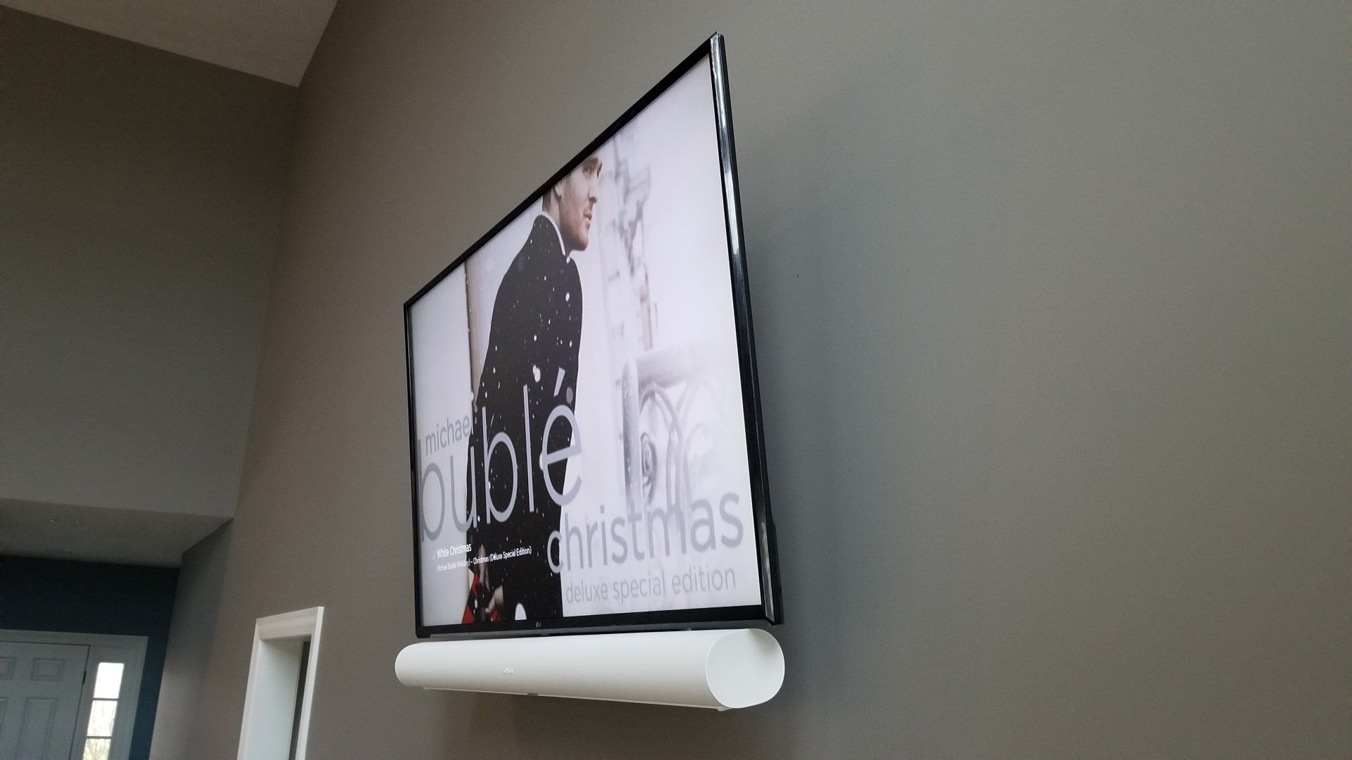 a flat screen tv is hanging on a wall with a sonos arc mounted by fisher electronics in northern ohio