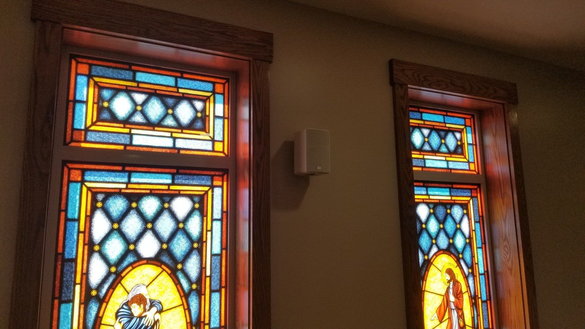 a pair of stained glass windows in a church with a new speaker system installed in northern ohio