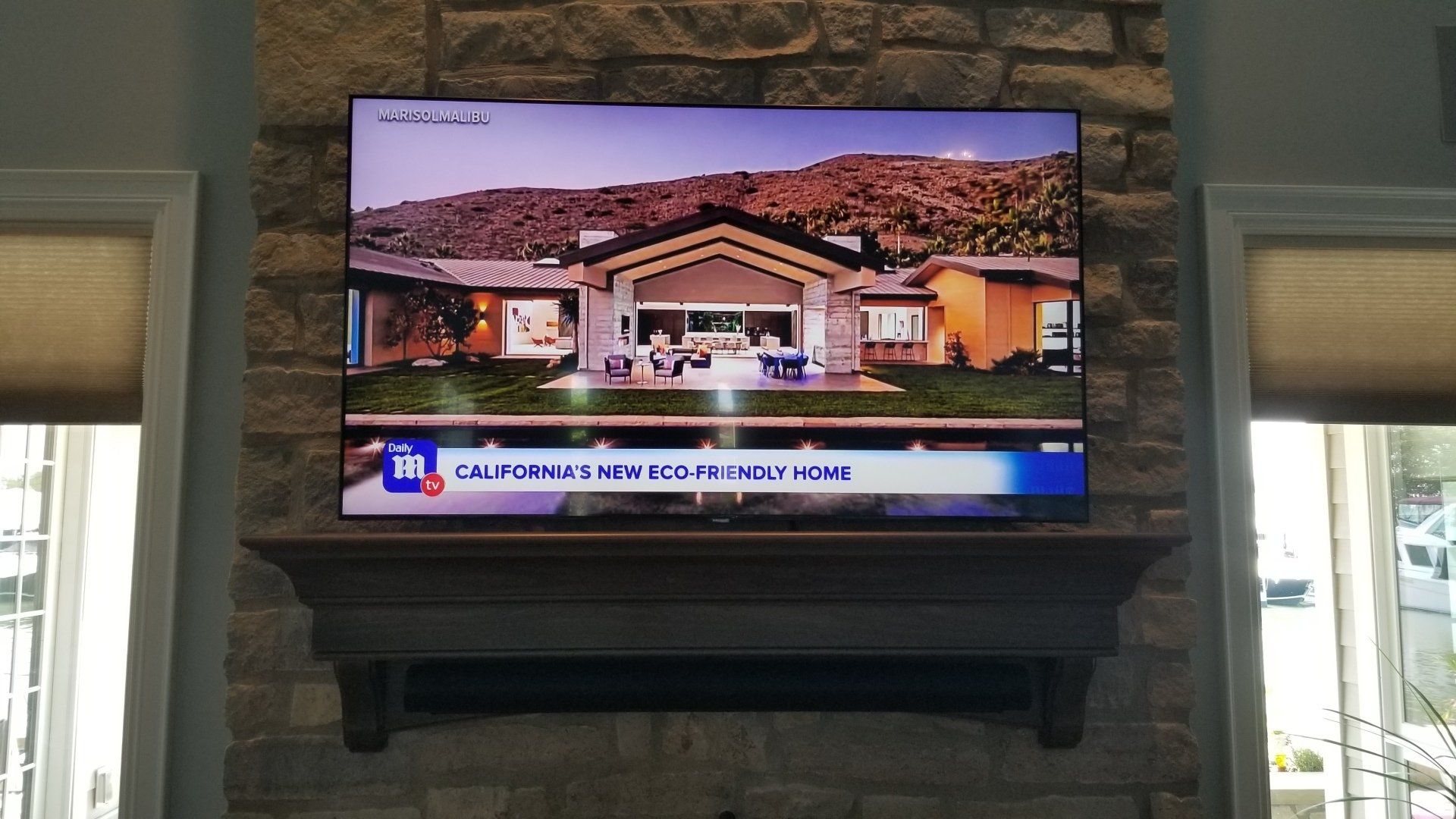 a television mounted above a fireplace mantle with a sonos arc soundbar mounted on the mantle below the TV by fisher electronics in northern ohio