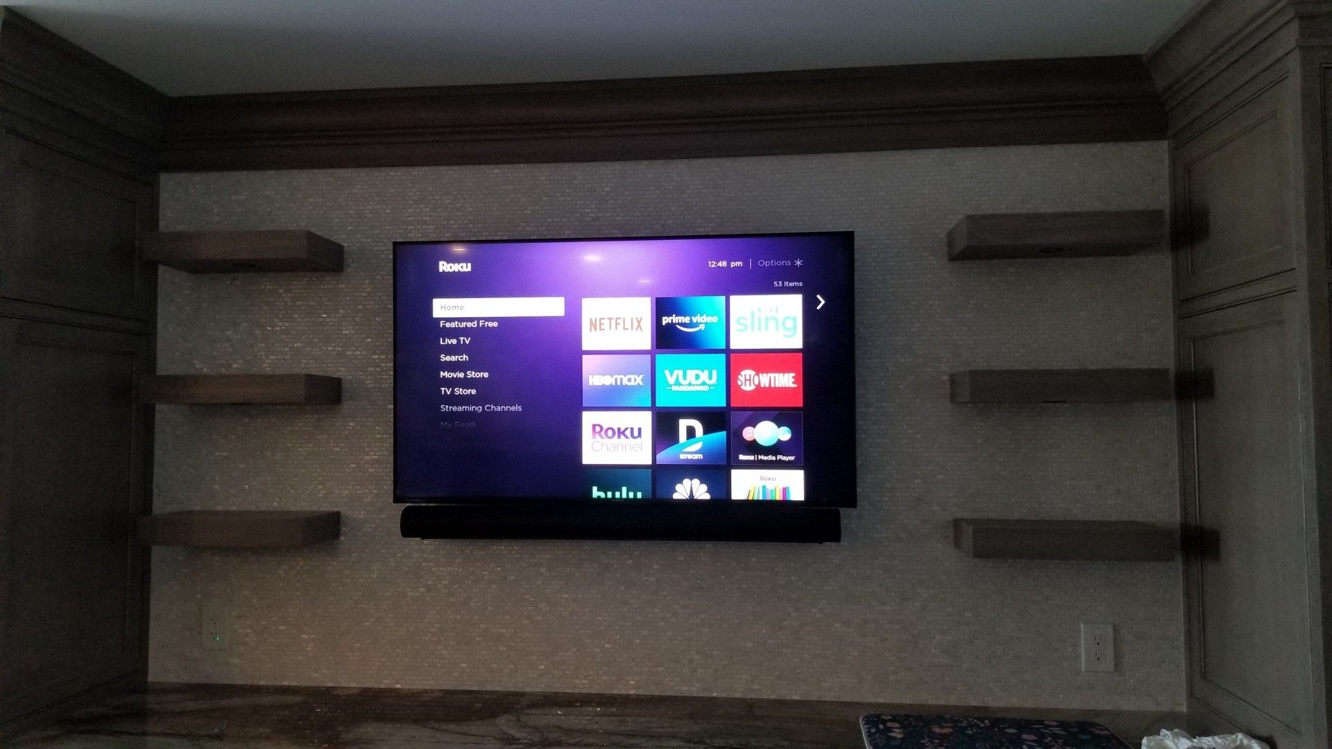 a tv is mounted to a tile wall with a sonos arc mounted flush at the bottom of the TV in vermilion ohio